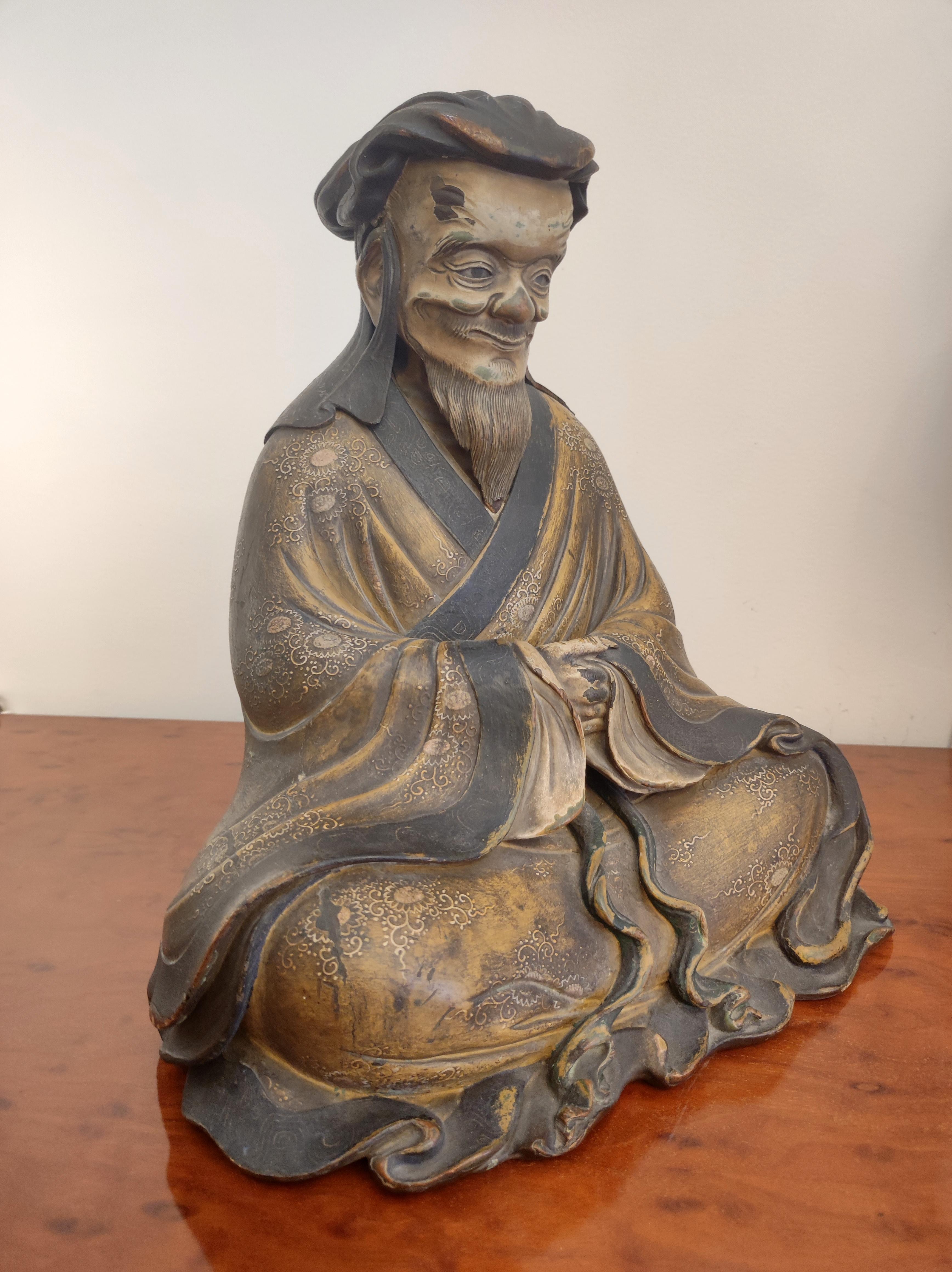 Statua di vecchio giapponese, epoca Tenmei, datata 1781
rappresentato seduto, con un abito lungo, decorato con fiori e fogliame, viso leggermente sorridente, occhi di vetro, con un cappuccio,
 testa rimovibile, che rivela un lungo testo all'interno