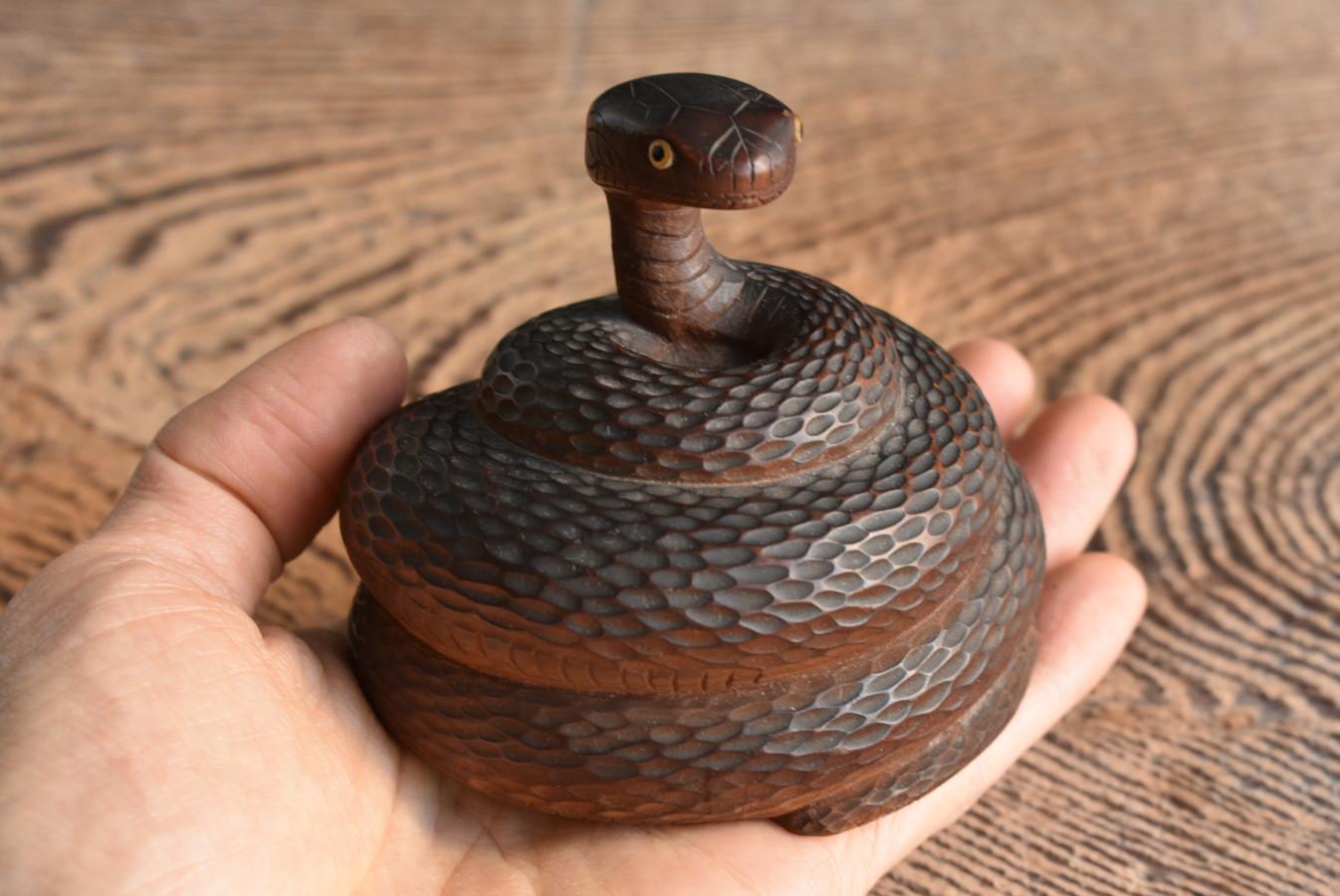 This is a wooden snake figurine made in the Taisho-early Showa period (1900-1950) in Japan.

Although it is a small palm-sized figurine, the expression of the snake and the expression of the scales etc.
It is reproduced finely.
The wood may be
