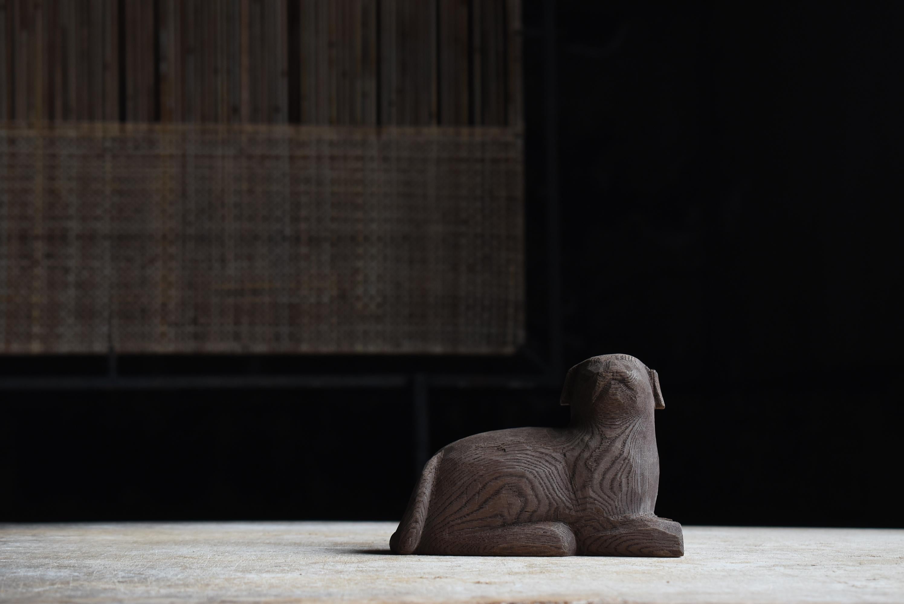 This is an old carved wooden dog made in Japan.
It was produced in the late Showa period (1950s-1970s) and is made of zelkova wood, which has a beautiful grain. The robust and expressive zelkova wood creates deep shades in the carving, giving the