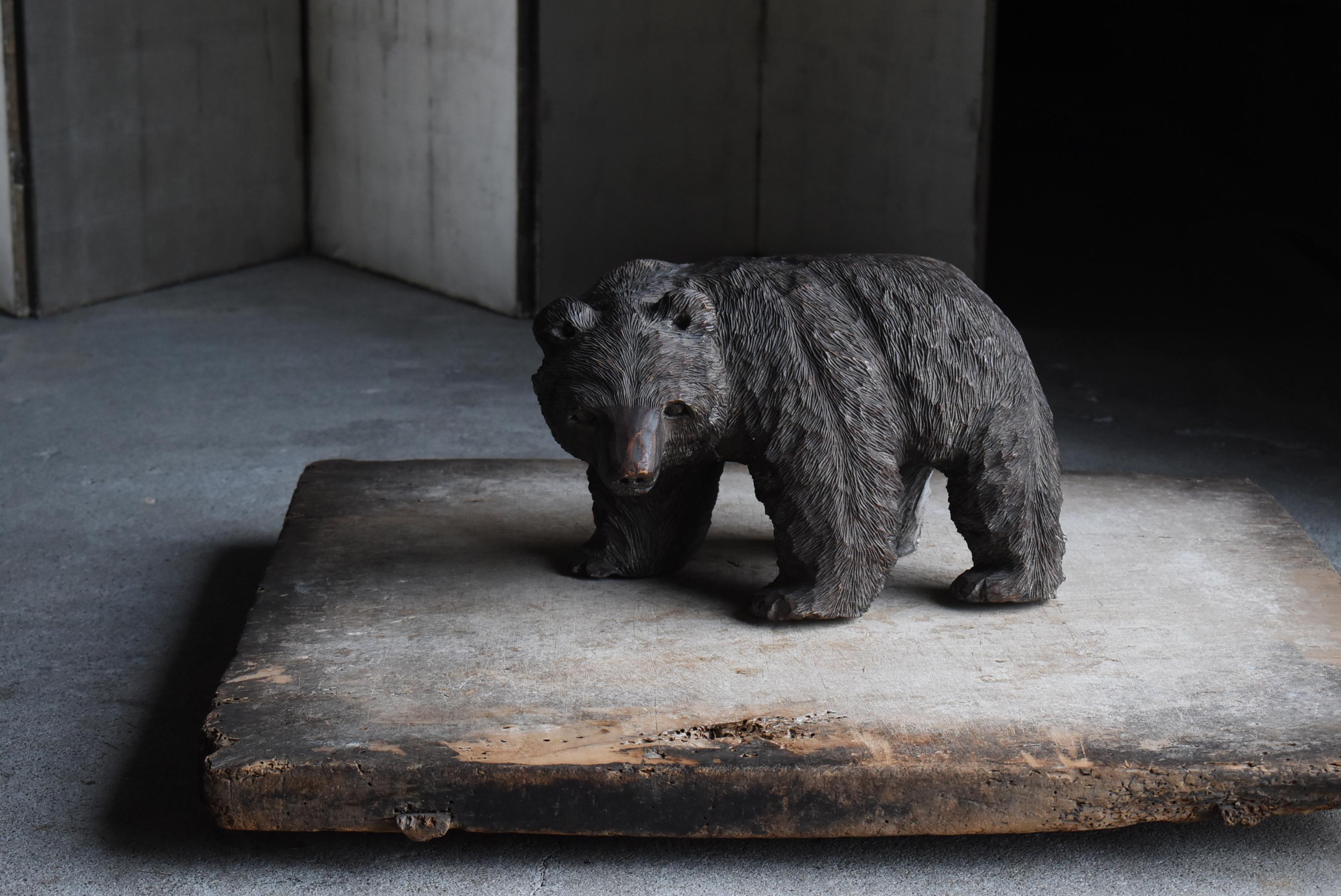 This is an old large Japanese wood carving of a bear.
It is carved on the back side of the paw that it was made in 1963.
The material is unknown, but it is made of a hard, heavy material.

This wood carving was found in Hokkaido, though the artist