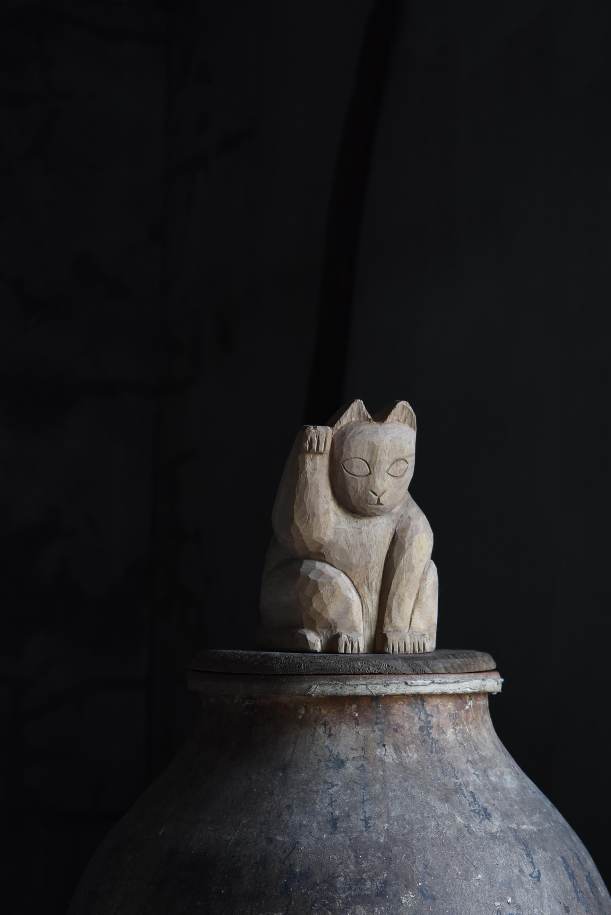 It is a Japanese old wood carving beckoning cat.
It is an item from 1940s to 1970s.

In Japan, it has long been familiar as a lucky charm of 