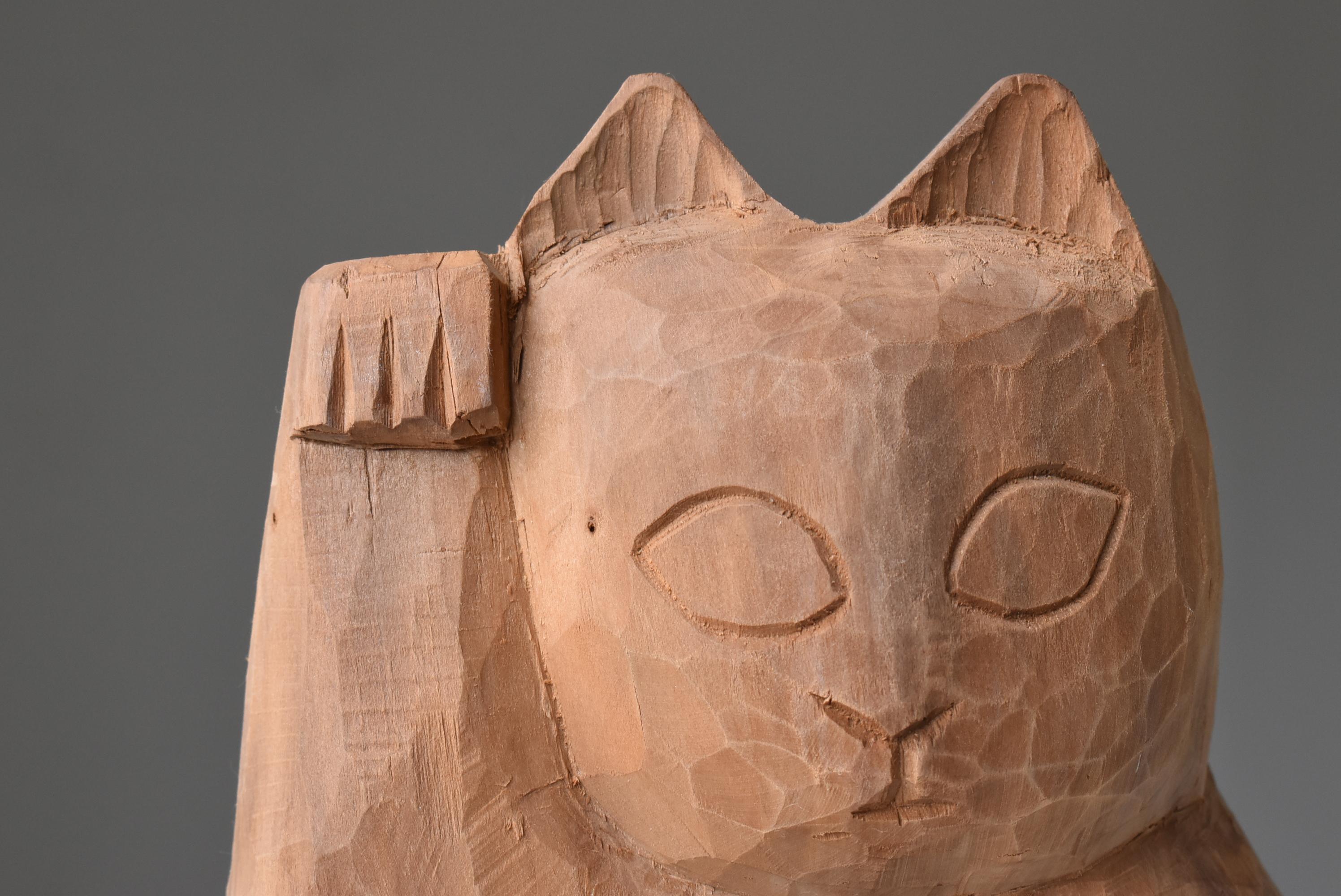 This is an old Japanese wood carving of a beckoning cat.
It is from the 1950s to 1970s.
The material seems to be cedar.

It has been popular in Japan for a long time as a lucky charm for 