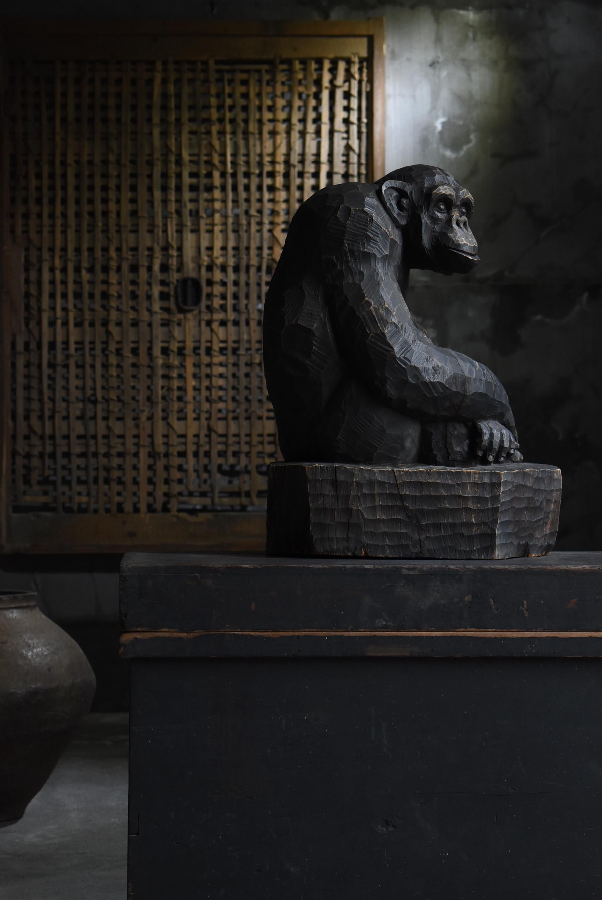 This is an old Japanese wood carving of a chimpanzee.
It is from the mid-Showa period (1940s-1960s).
It is made of camphorwood.

It is a dynamic work boldly carved from a large tree.
The chimpanzee's form is accurately expressed while leaving the