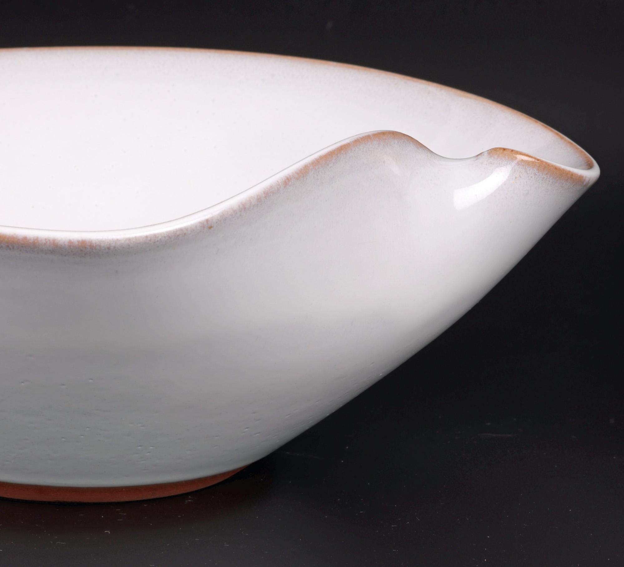 A large and impressive Japanese white glazed orangic shaped studio pottery bowl dating from the 20th century. The heavily made stoneware bowl is of deep rounded shape with kinked rim formed as thumb rest to enable the bowl to be easily balanced and