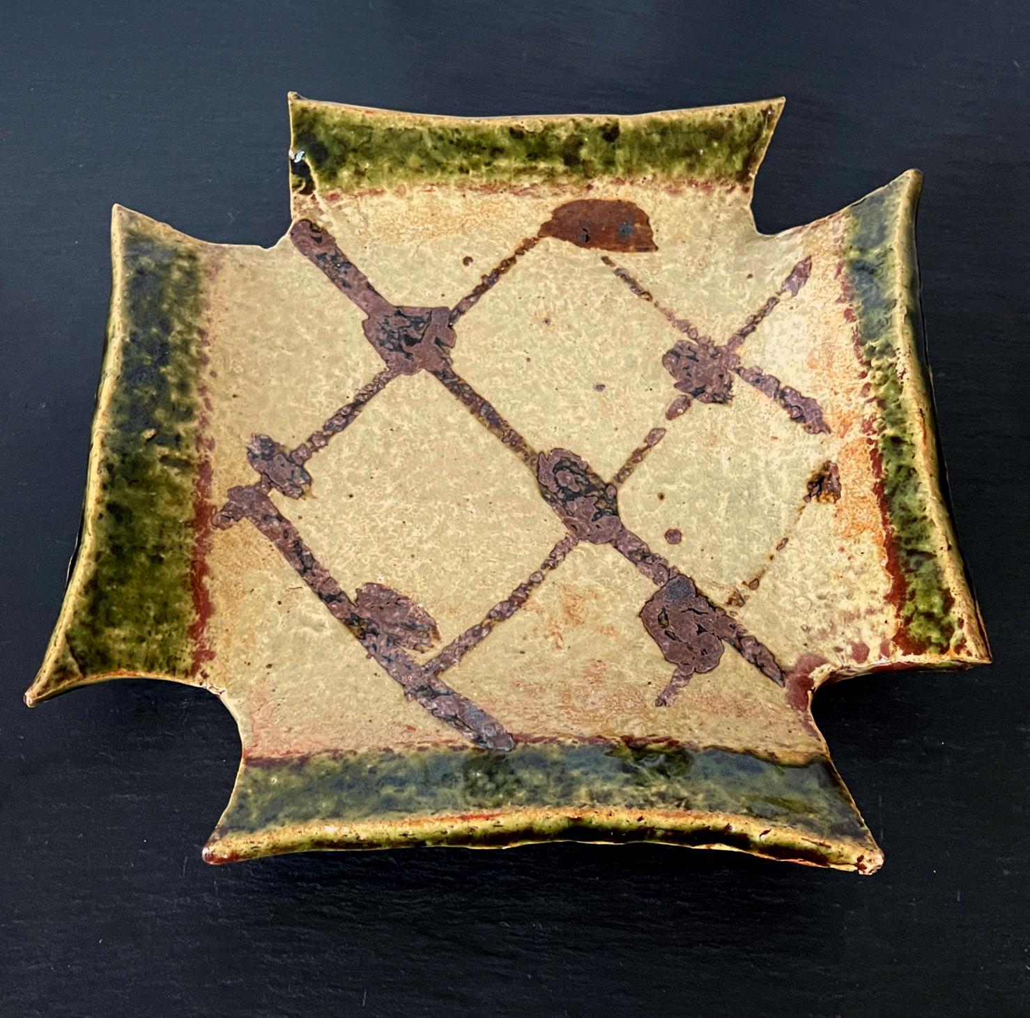 An oribe stoneware square dish with four notched corners and up-turned edges made by Kitaoji Rosanjin (1883-1959) circa 1950s. The Mingei style dish has a wonderful casual form with green glaze outlining the sharply shaped edges. The interior