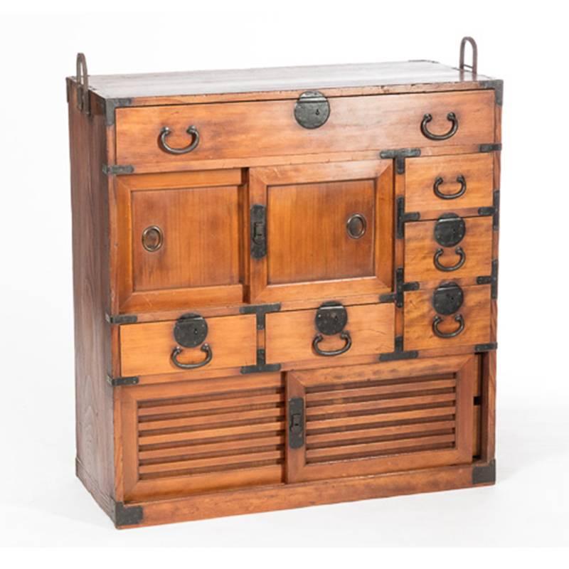 This is a gorgeous example of a choba dansu, merchant's shop storage chest from Osaka, Japan. 
A fully restored cabinet featuring a fine quality cypress exterior and a paulownia wood interior, with wrought iron handles and joinery. Dating from the