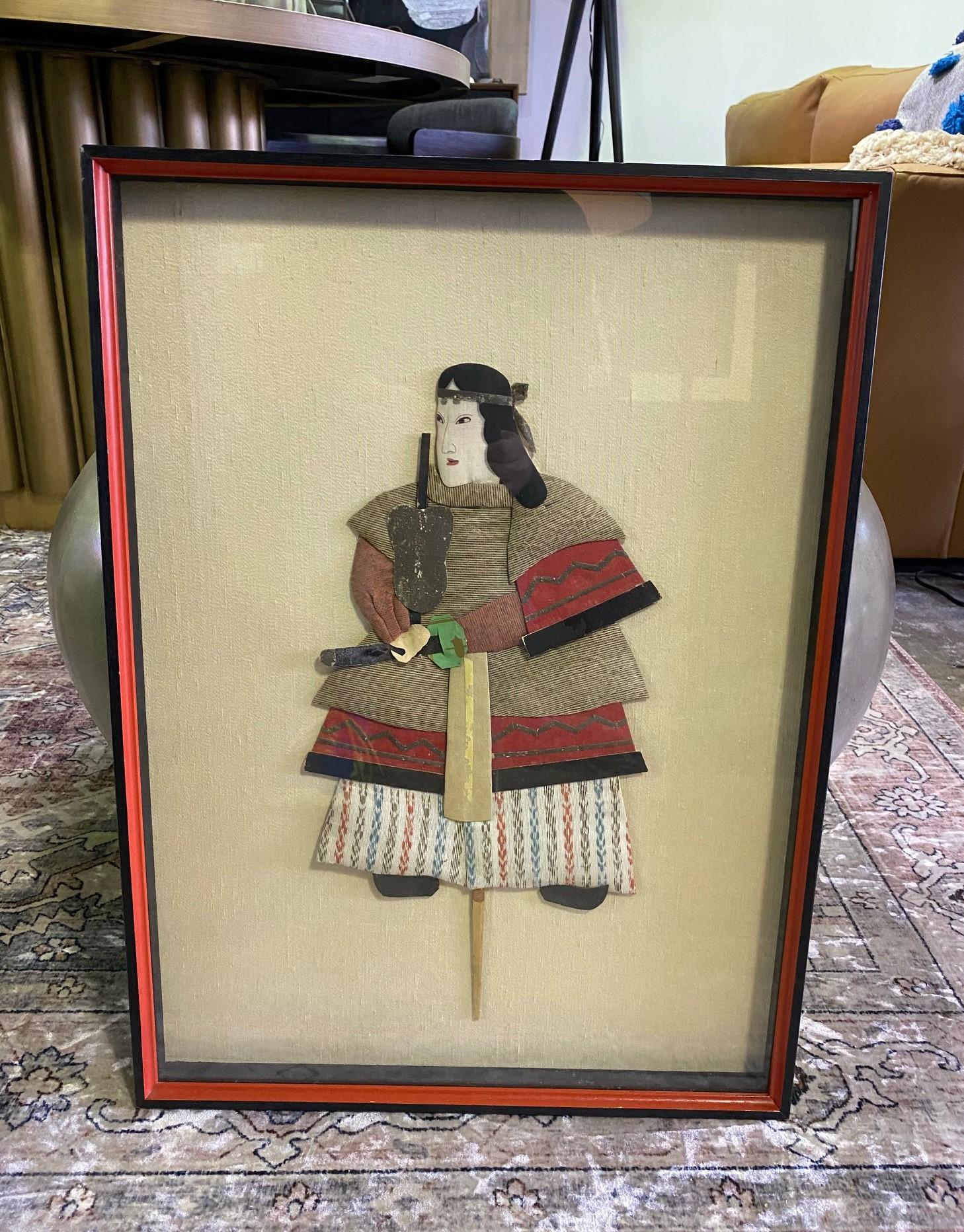 A wonderful, handcrafted work of a Japanese samurai/warrior doll shadow puppet.

Oshie, which translates as pressed pictures, is a traditional Japanese art form that can be traced back to the Edo period and usually consist of paper and sections of