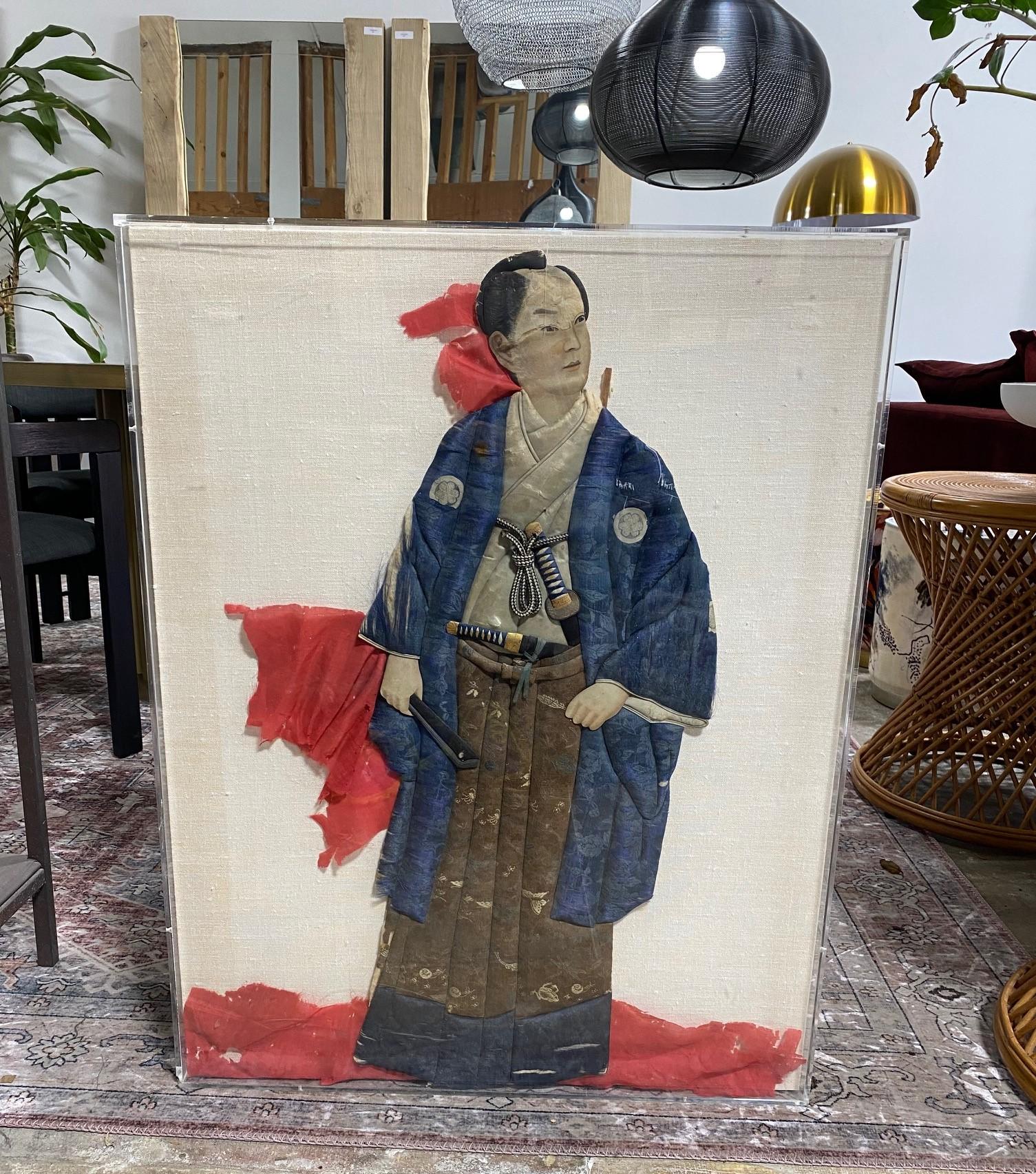 A wonderful, handcrafted work of a regal Japanese samurai/warrior doll shadow puppet.

Oshie, which translates as pressed pictures, is a traditional Japanese art form that can be traced back to the Edo period and usually consist of paper and