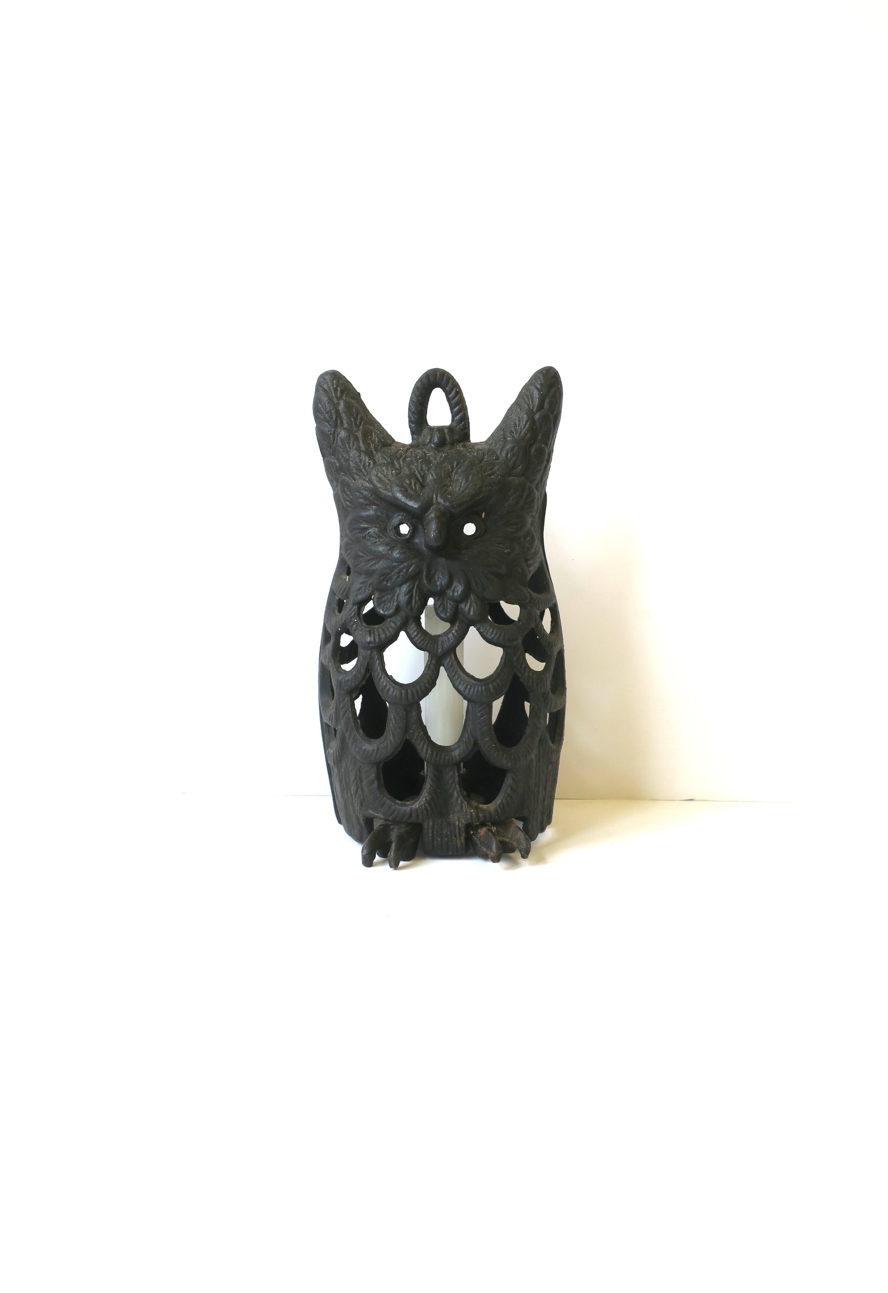 A substantial vintage Japanese owl candle lantern made of blackened iron. Lantern holds a tapper candle within its base area. Owl's body is beautifully designed with 'perforated feathers' allowing light to flow. Lantern can stand on its own or be