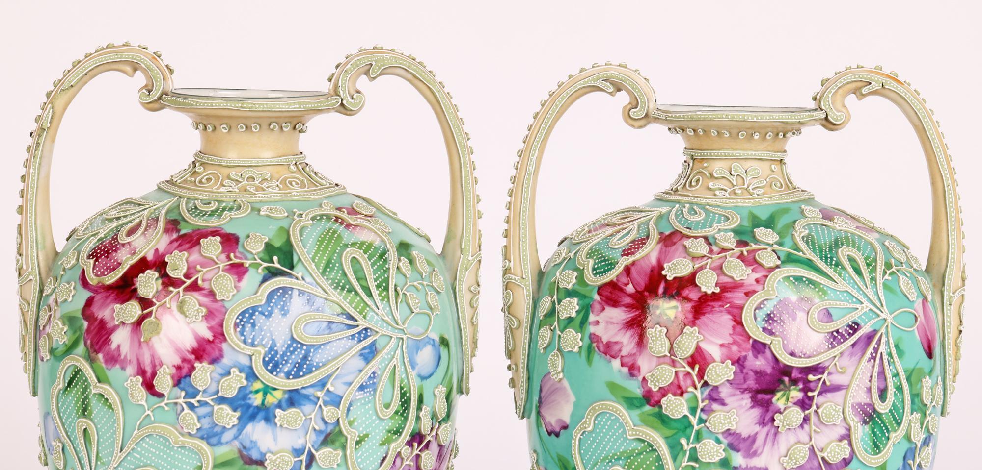 An exceptional pair Japanese Meiji twin handled decorated with moriage patterning on a floral painted ground dating from around 1900. The porcelain vases stand on a shaped round foot with a narrow stem and large round bulbous body with a narrow neck