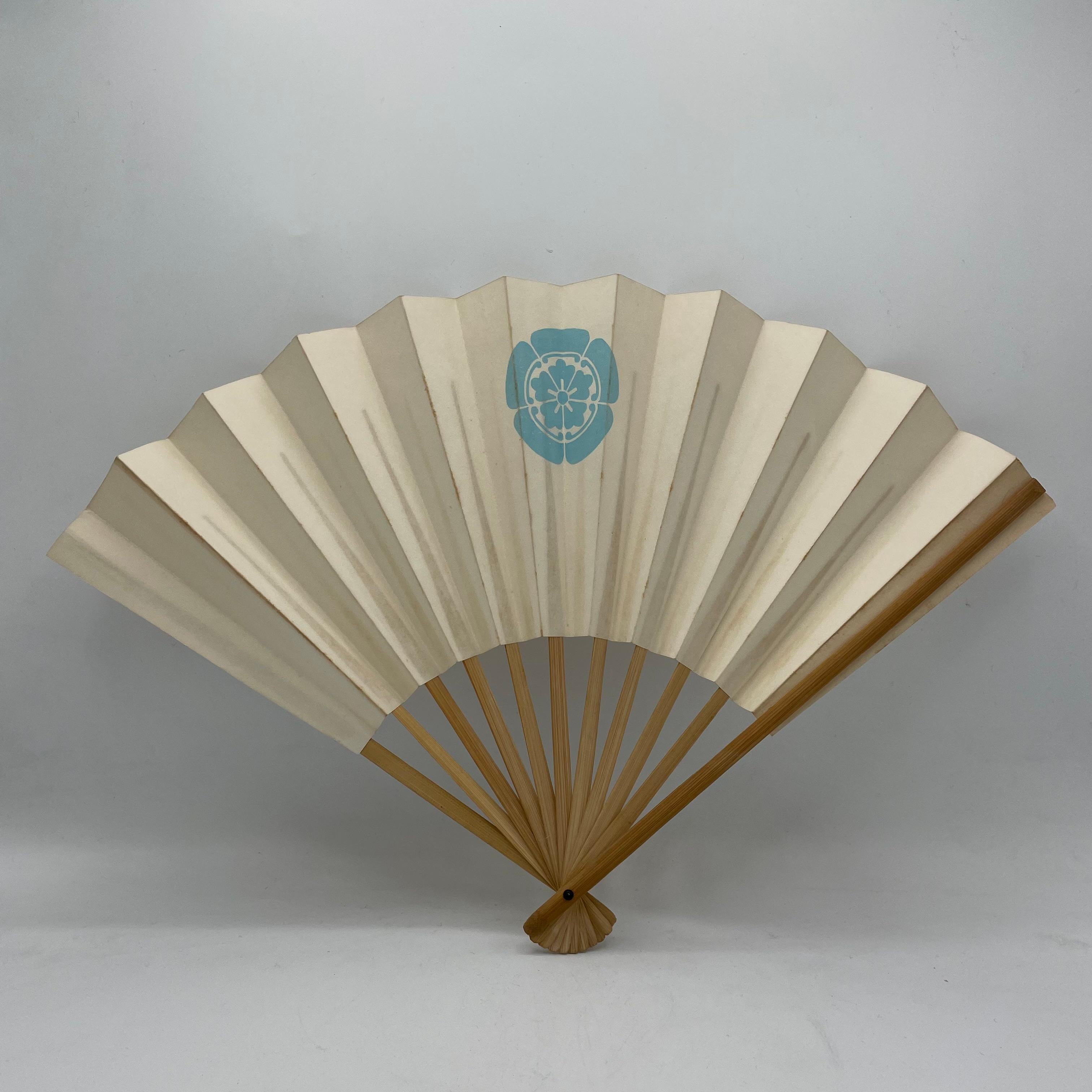This is a paper fan with bamboo which was made in Japan around 1990s.
In the middle, there is a logo (Family crest) which is called Kamon in Japanese. This kamon is called Odamokko.

The Odamokko is a traditional Japanese family crest (kamon)