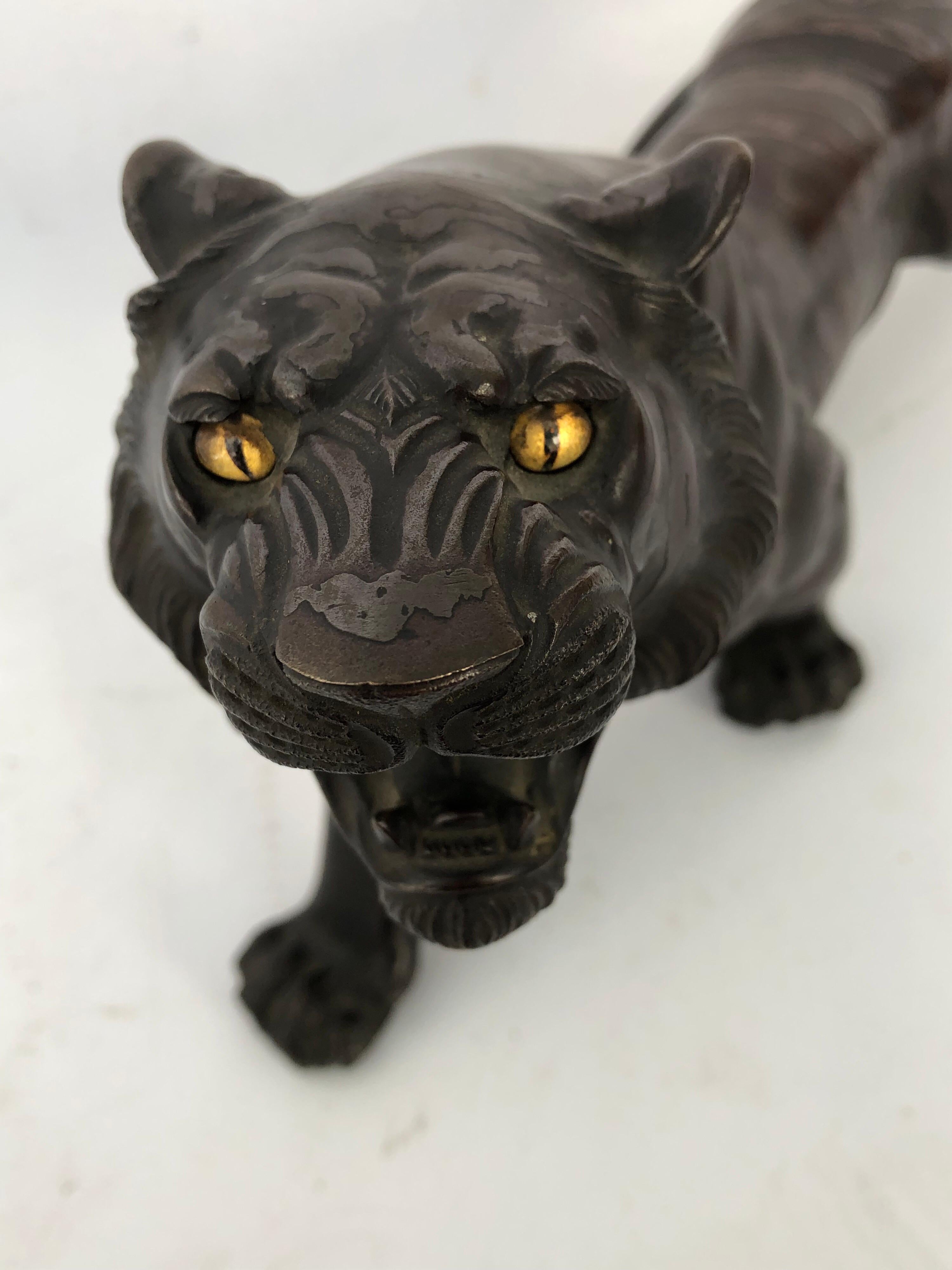 Japanese bronze patinated figure of a prowling tiger. Glass/crystal eyes, two metal
bronze body, replicating tiger stripes. Two character mark on base. Probably Meiji, late 19th-early 20th century.