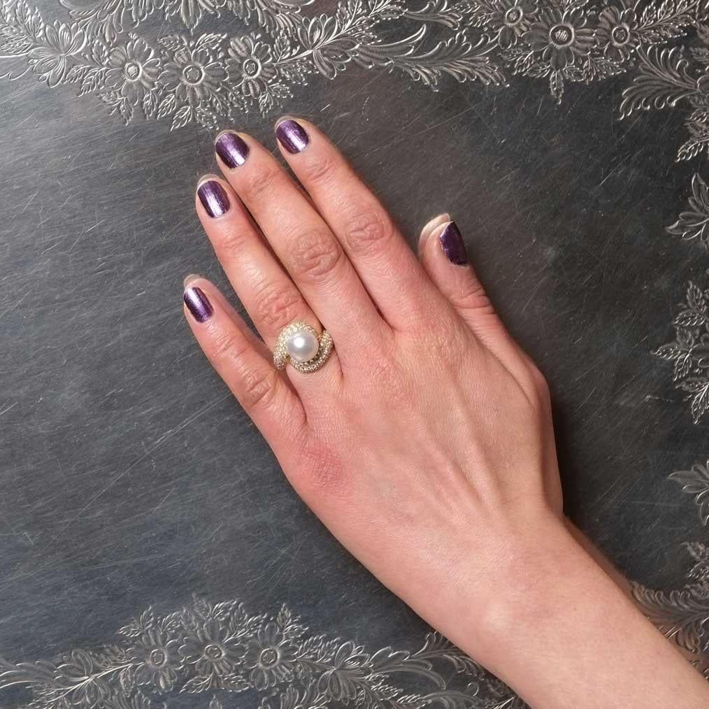 This 1960s ring is set in 18ct gold with a 9mm Japanese cultured pearl and round cut diamonds.

Highlights
- 1960s
- 18ct yellow gold
- Round cut diamonds

Measurements
- Width 1.8cm
- Weight 7g
- Italian ring size 8.5 (size can be altered if