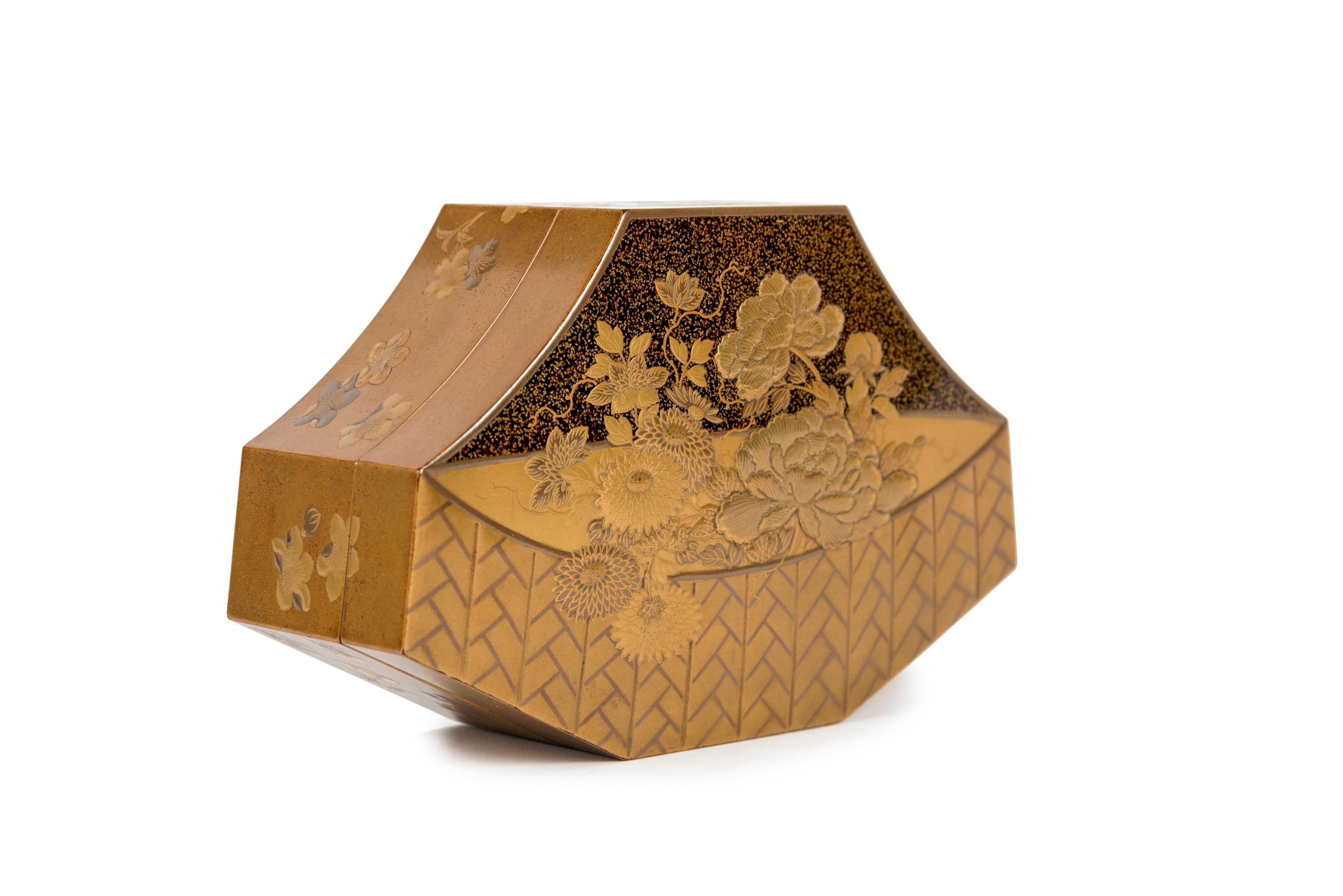 Eight-sided, flared shaped lacquer kobako box, following the decoration on the lid depicting a basket of flowers, composed of peonies and chrysanthemums in gold takamaki-e and hiramaki-e lacquer on a nashi-ji background. The edge is decorated with