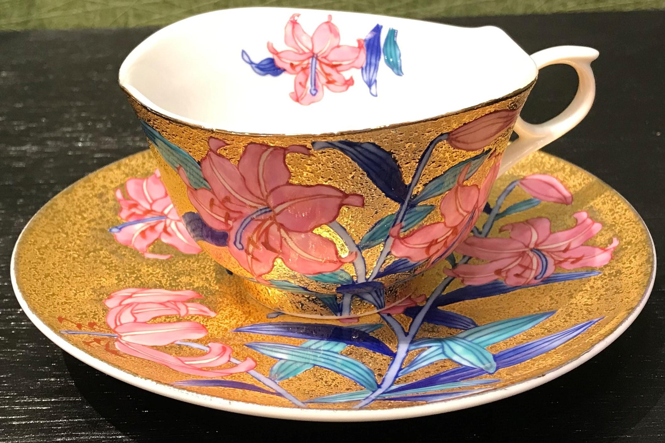 Stunning contemporary gilded porcelain cup and saucer, intricately hand painted in vivid blue, green and pink on an attractive gilded body, featuring graceful lilies in full bloom.
This cup and saucer is from a signature series by a highly respected