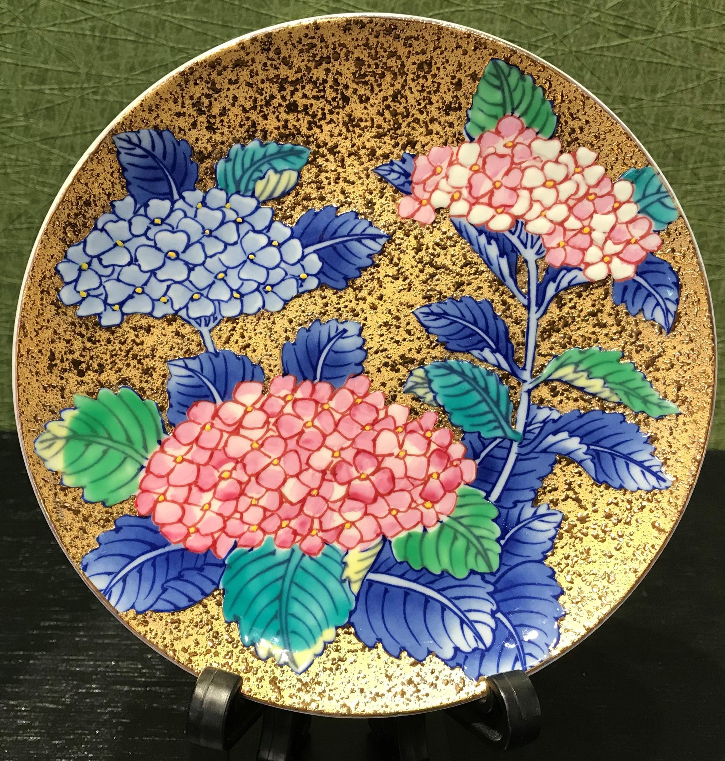 Exceptional contemporary gilded porcelain cup and saucer, intricately hand painted in vivid blue and pink on an attractive gilded body, featuring stunning hydrangeas in full bloom.
This cup and saucer is a masterpiece from a signature series by a