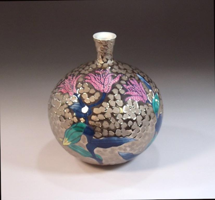 Japanese contemporary dimpled decorative porcelain vase, hand painted in blue and pink on an elegant bottle shaped porcelain body against a stunning dimpled platinum background, a signed piece by widely acclaimed Japanese master porcelain artist in