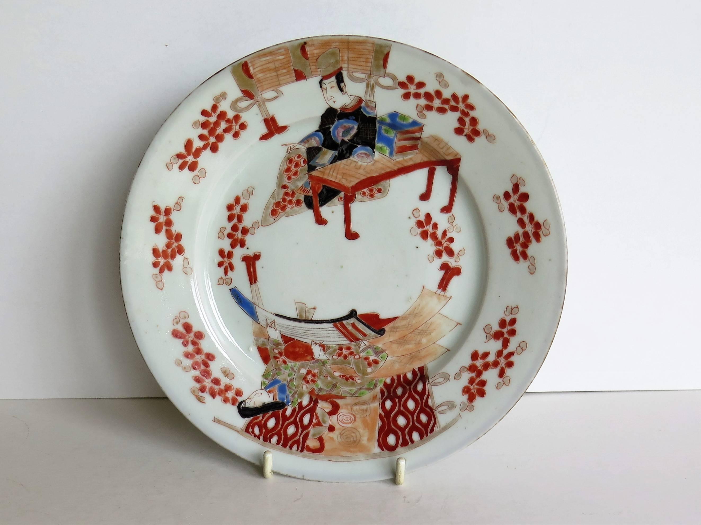 This is an unusual Japanese porcelain plate or dish which we date to the 19th century, Meiji period, circa 1880.

The porcelain plate is circular with a double base foot rim which is unusual.

The decoration shows a man and a woman sat at two