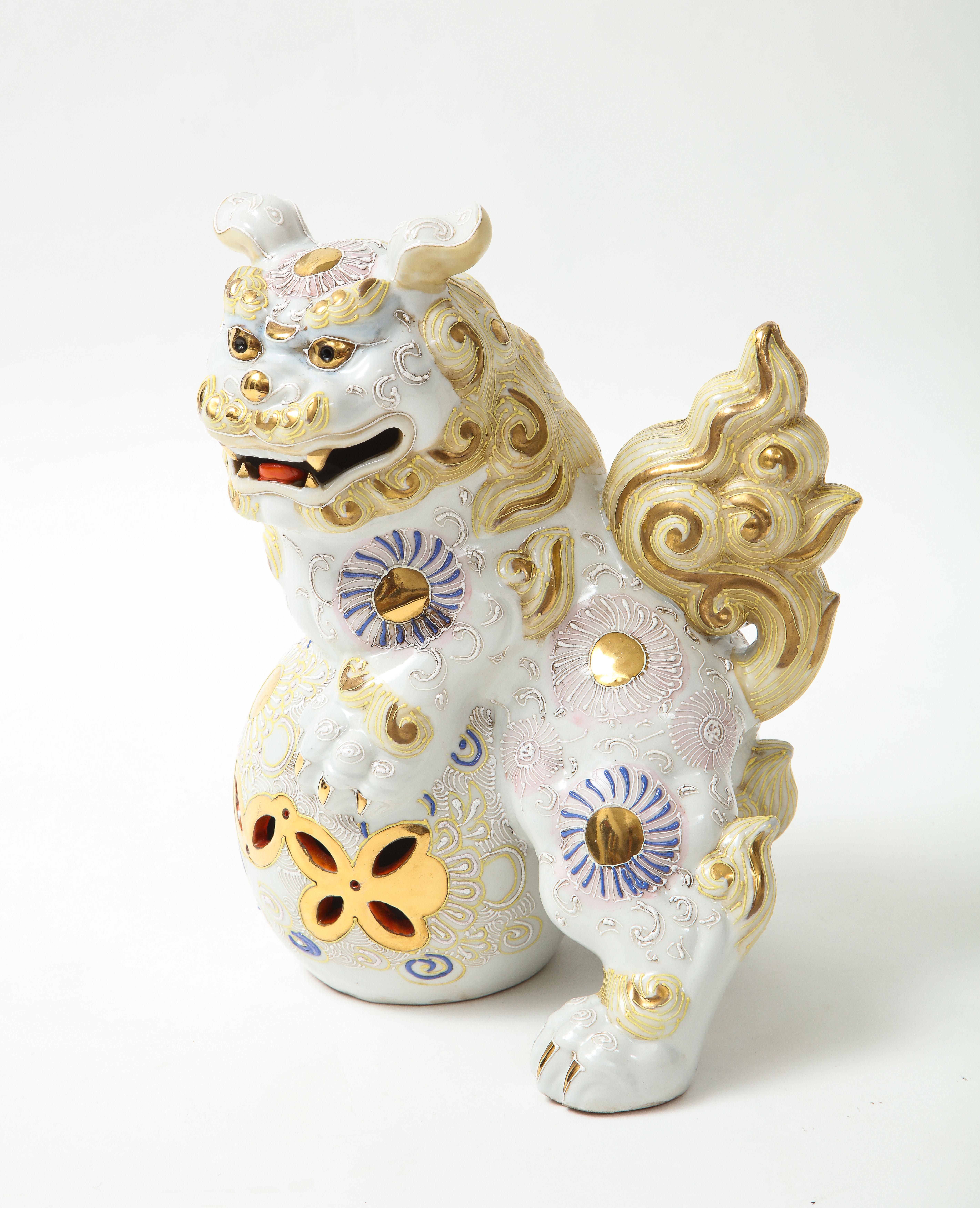 Mid century white porcelain hand decorated foo dog with yellow and blue glaze colors and git accents.