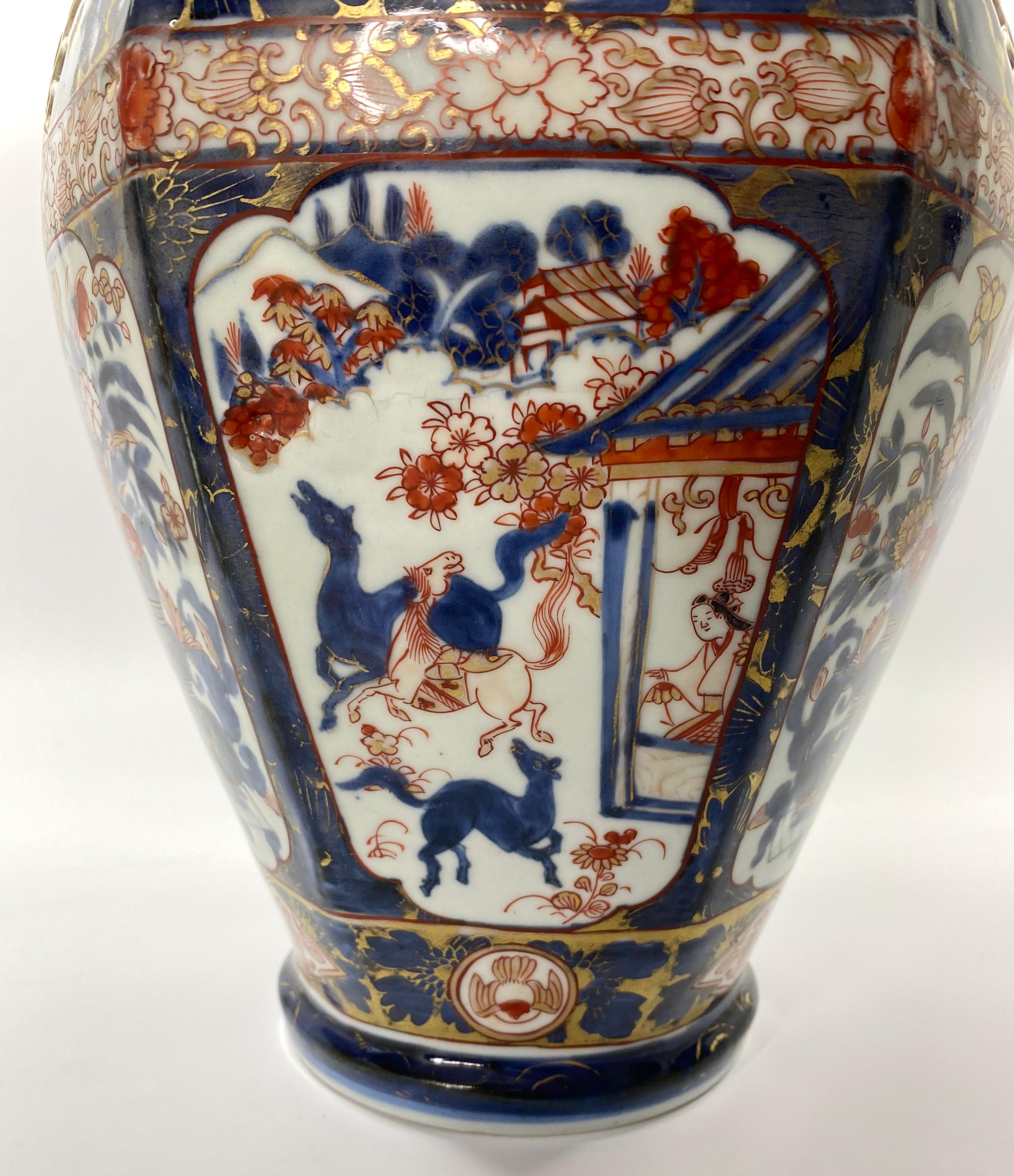 Japanese ‘Imari’ porcelain vase, Arita, c.1700. Edo Period. The hexagonal shaped vase, hand painted with panels of a bijin watching horses playing before a pavilion, in a landscape, alternating with panels of jardinieres containing flowering