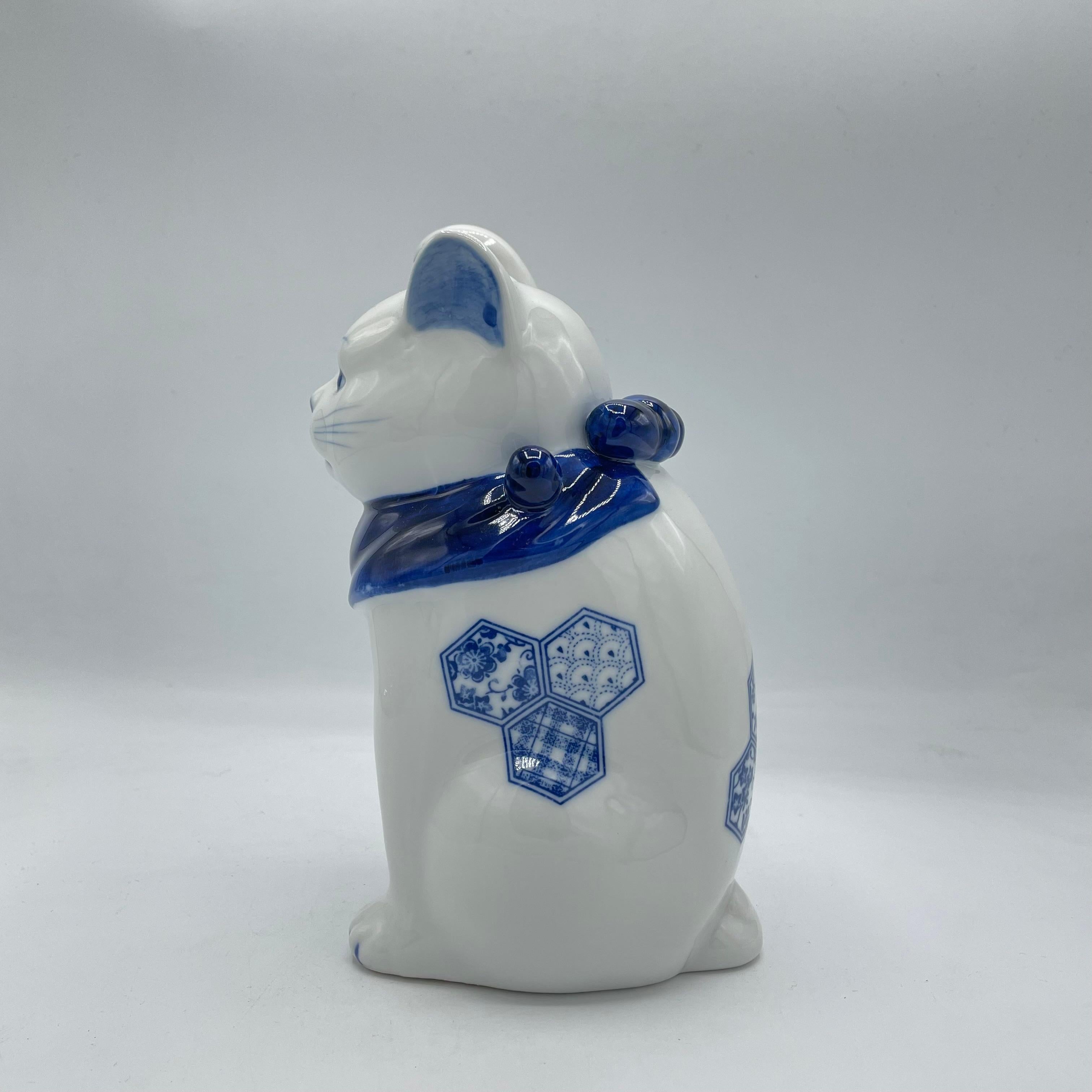 Si tratta di un gatto portafortuna manekineko prodotto in Giappone intorno agli anni 2000.
È realizzato in porcellana. 

---
Il Maneki-neko è una figura giapponese che porta fortuna e fortuna. 
Di solito è realizzato in porcellana e raffigura un