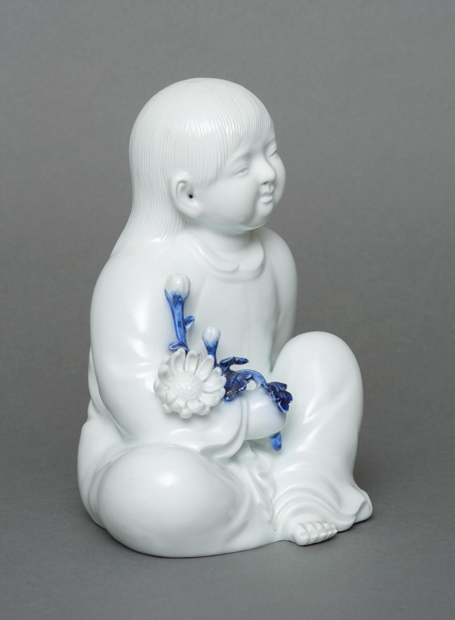 Porcelain Japanese porcelain okimono 置物 of a sitting child, by Sakaida Kakiemon XII