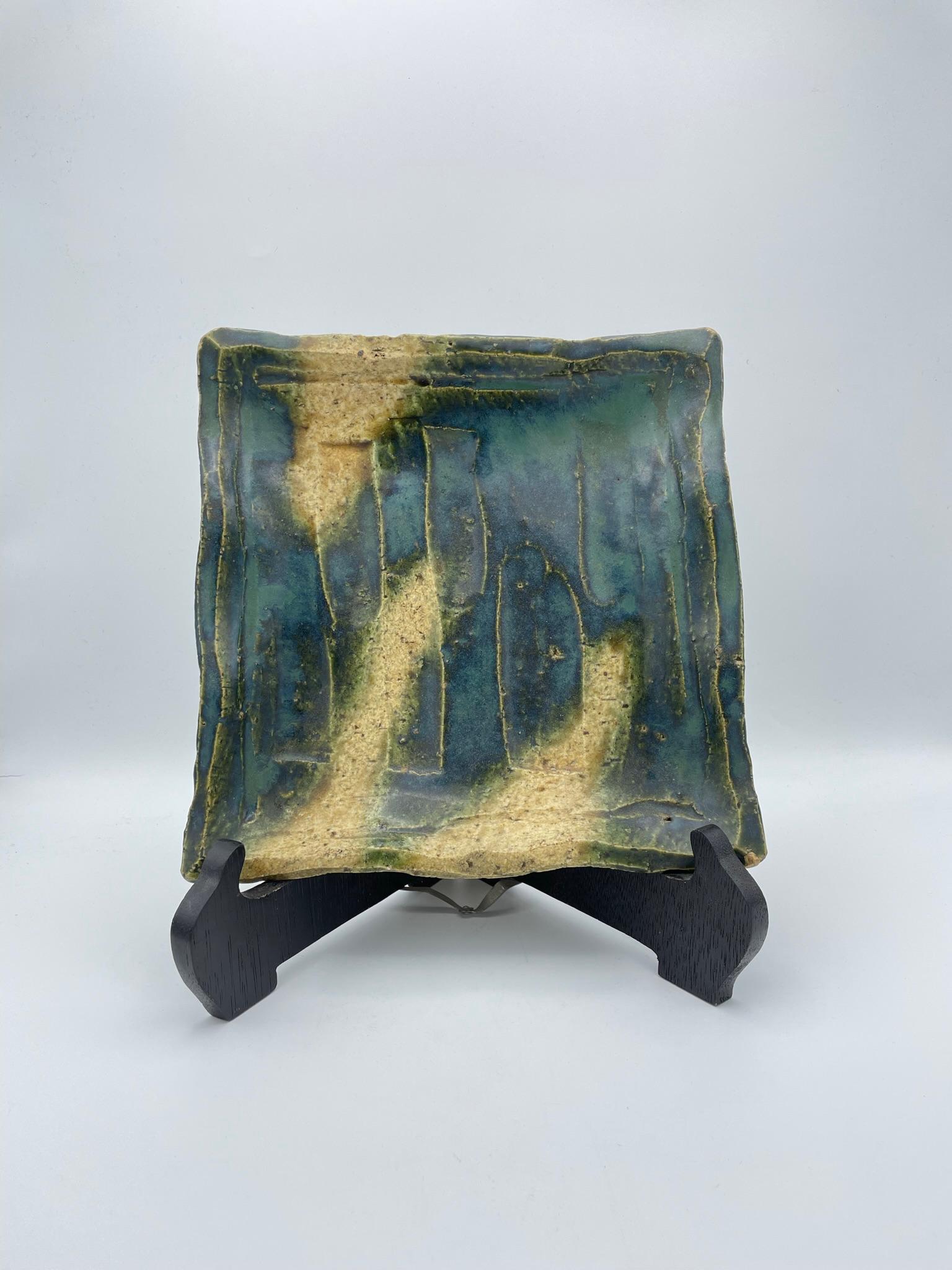 This is a square plate for serving food or decoration.
This is made with technique Oribe (Oribe ware) and made around 1960s. 
Oribe ware is from Gifu prefecture in Japan.

Dimensions:
H4 x 23 x 23 cm.

 