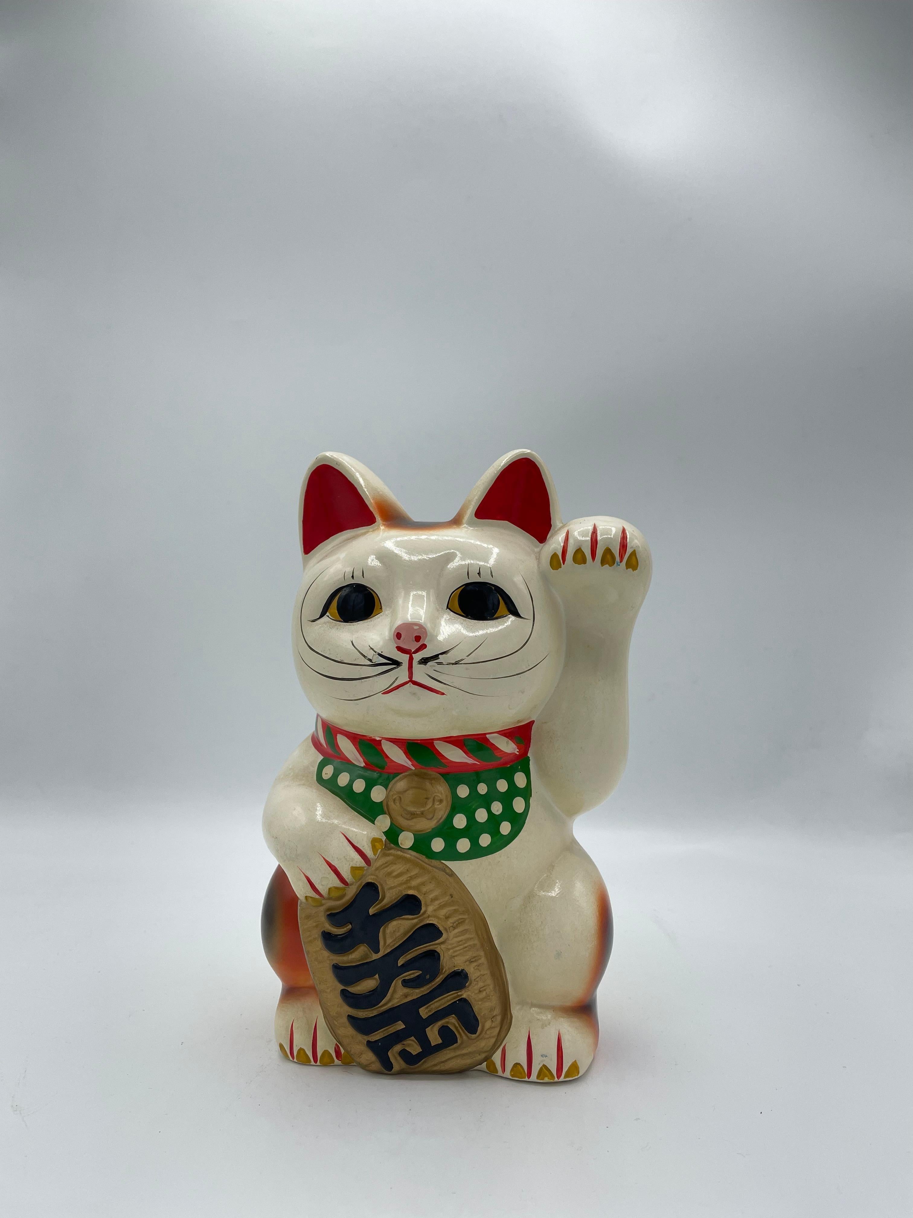 This is a piggy bank of manekineko cat. It is made with Pottery and it was made around 1980s in Showa era.

The maneki-neko is a common Japanese figurine which is often believed to bring good luck to the owner. In modern times, they are usually made