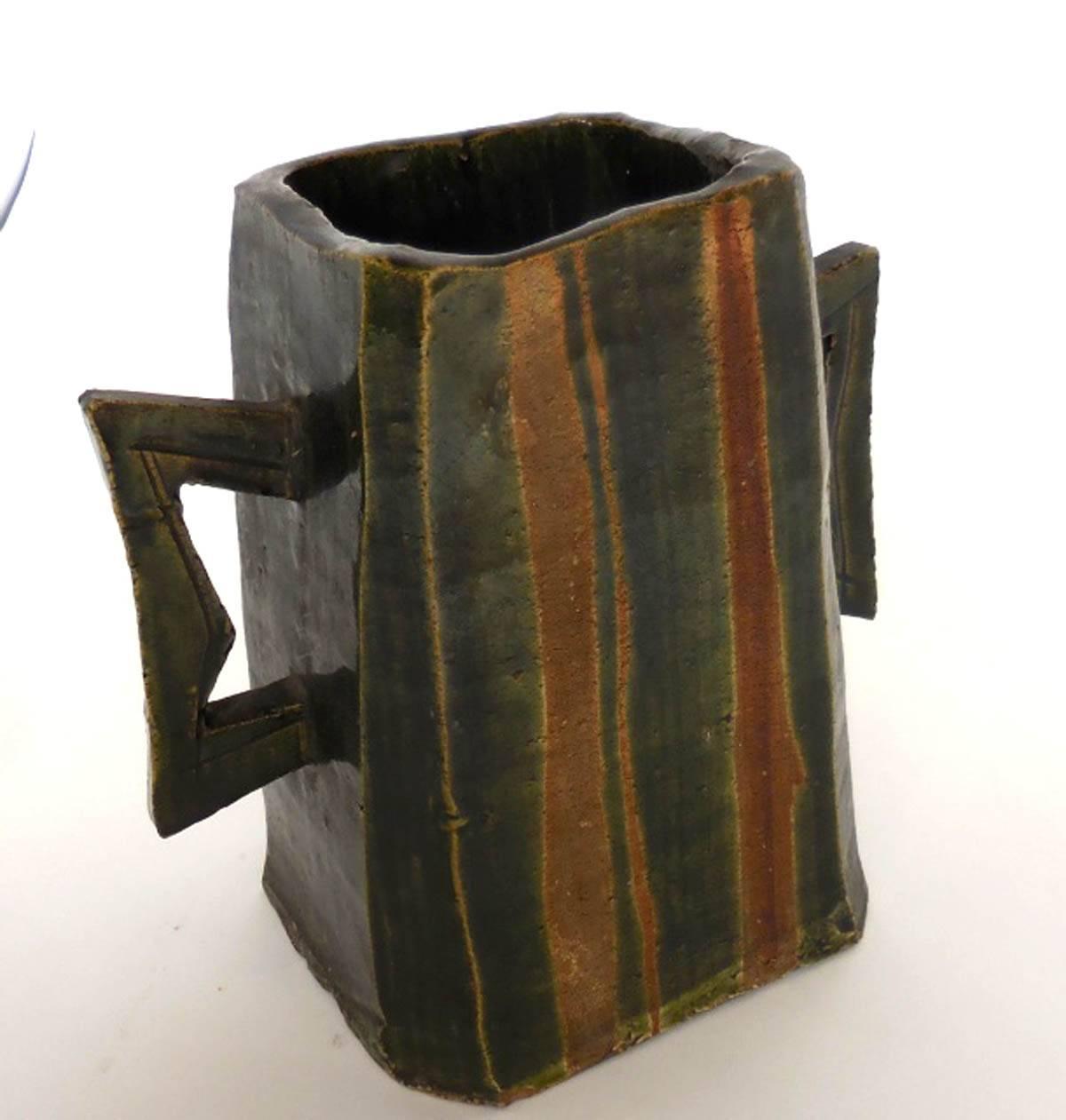 Mid-20th century art pottery vessel, signed by the artist. Green is the overglaze and the orange is the unglazed pottery beneath it. It is in great condition! It's cool and geometric!
 