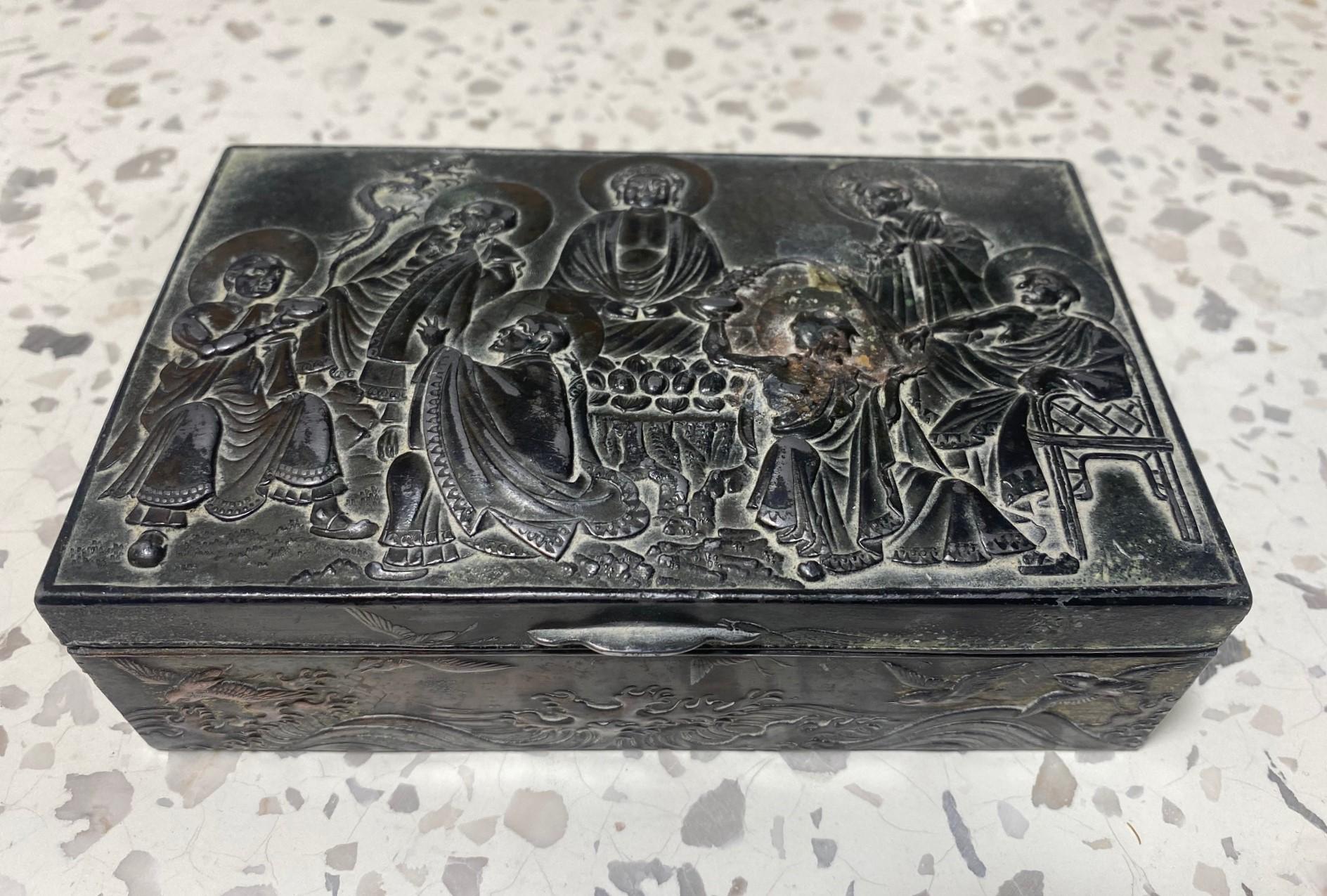 A beautifully crafted and artistically detailed pressed Repousse-designed metal (we were told by the previous owner that it is possibly silver plated on copper but we have not tested it to verify) Japanese collectible trinket or tobacco box.  The