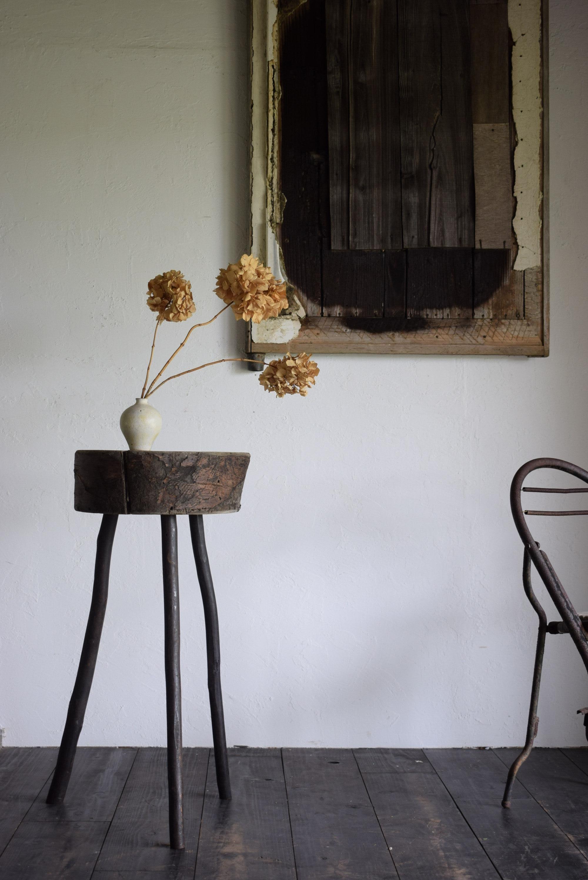 This flower stand was made from a stump that was once used as a workbench, with three branches as legs. Its appearance is very Japanese, and it is a stand that exudes the wabi-sabi aesthetic. The delicate, slender legs and the simplicity of the