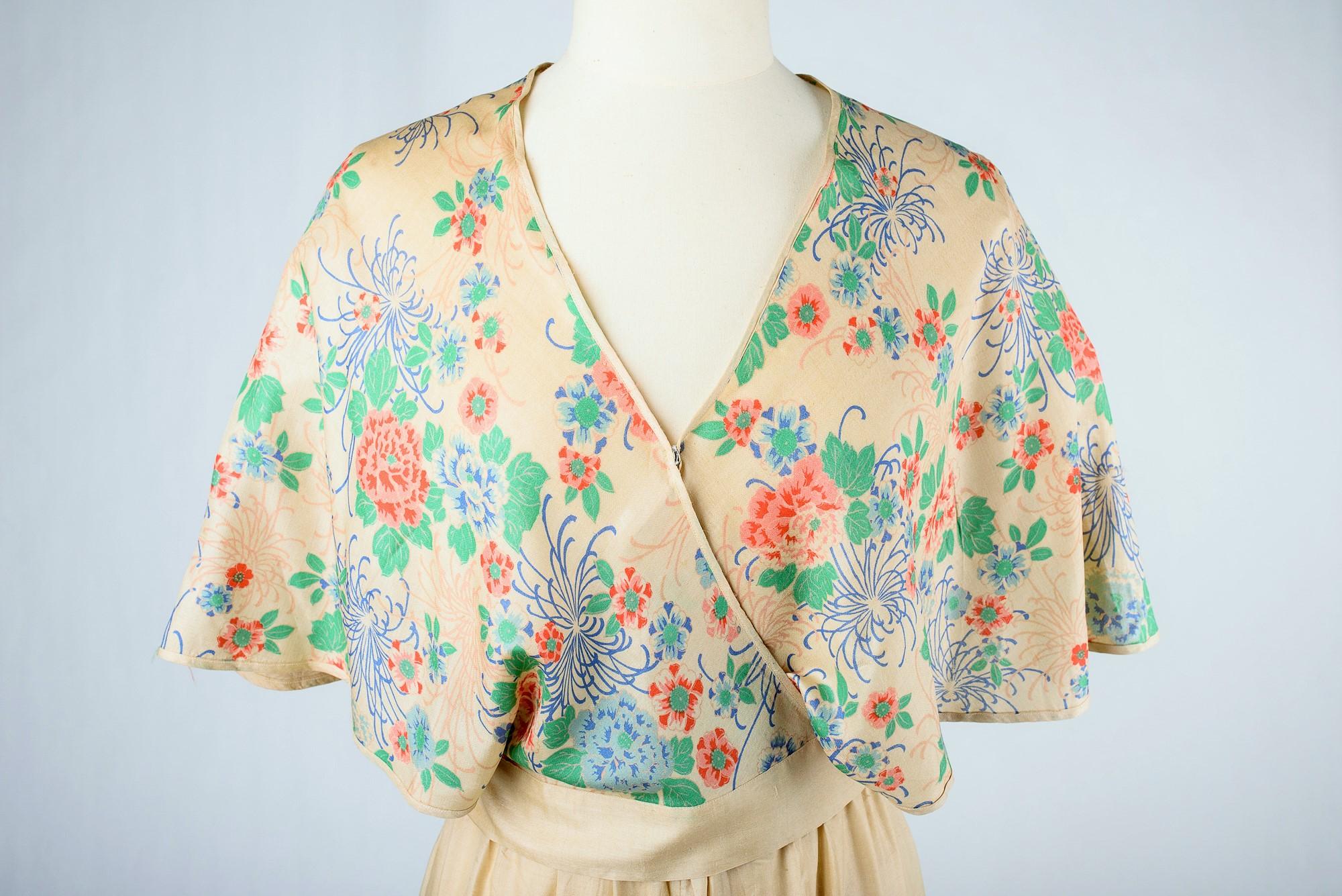 Circa 1935

France

Beautiful evening pajamas, two pieces Cache-Coeur and pants in cream silk pongee printed with Japanese motifs and dating from the 1930s. Beautiful print with bunches of chrysanthemums for the blouse with large panels covering the