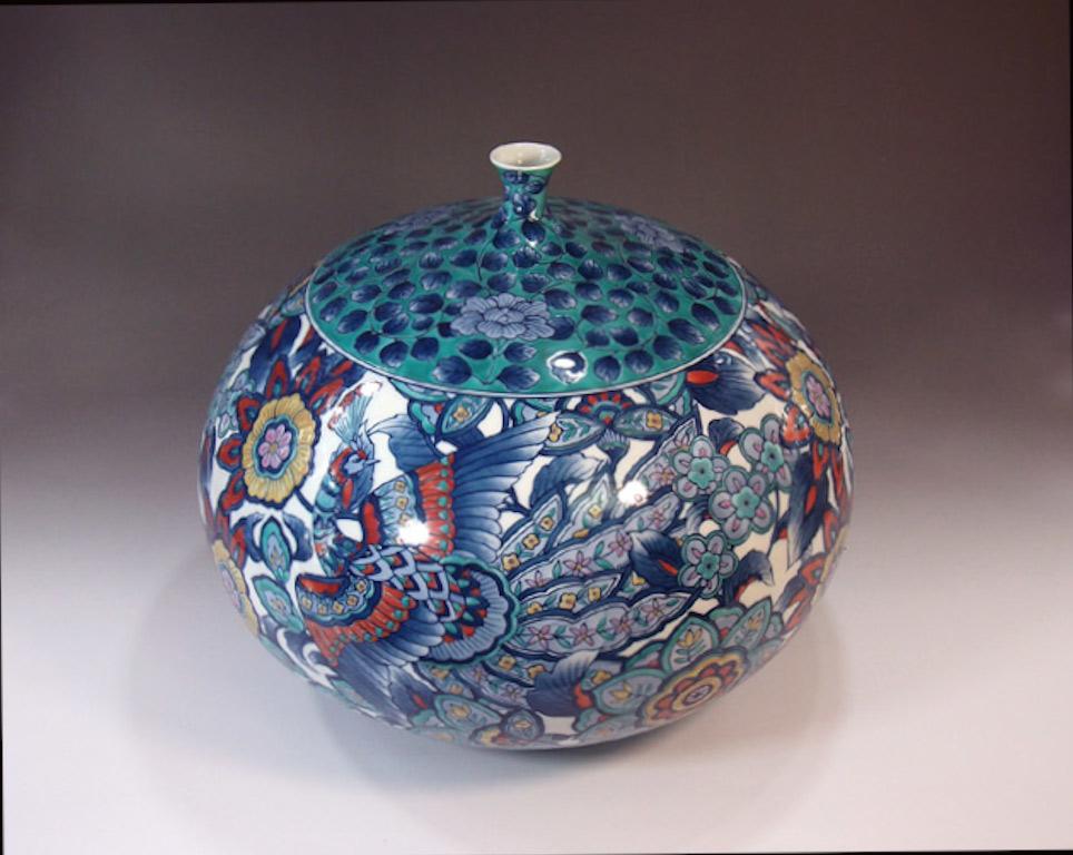 Vase décoratif unique en porcelaine japonaise contemporaine, peint à la main de manière complexe dans des teintes de rouge, de bleu, de violet et de vert sur un corps ovoïde saisissant, une œuvre signée par un maître porcelainier primé et hautement