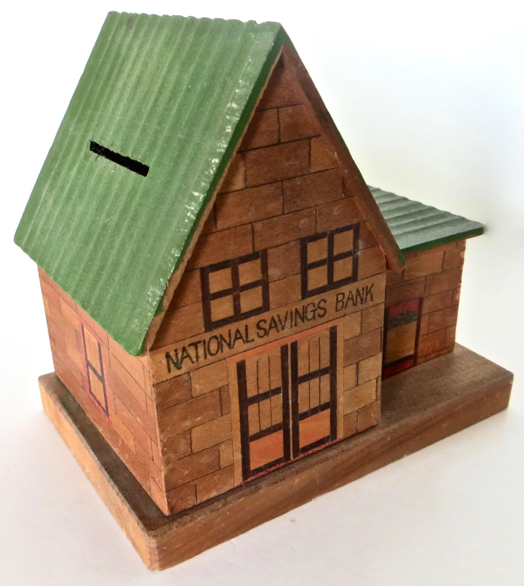 Quite an unusual piece for bank collectors or just for those seeking a unique collectible. This is a coin bank made of all wood; walnut and inlay here and there with a green painted roof; portraying an institutional bank; in this case, 