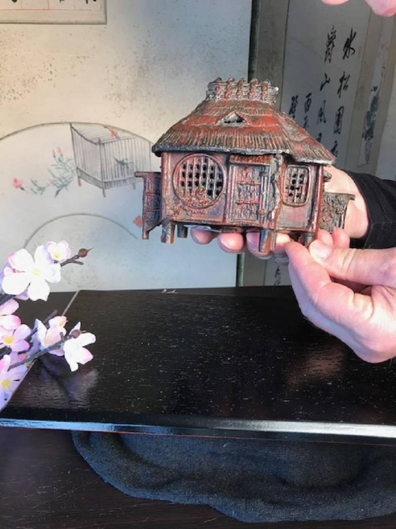 Japan, an authentic and seldom encountered solid cast bronze Kusaya farm house form two part censer dating to the early 
Taisho period 1915. It is signed on bottom.

Cast in a red bronze color in two sections, this censer possesses all the