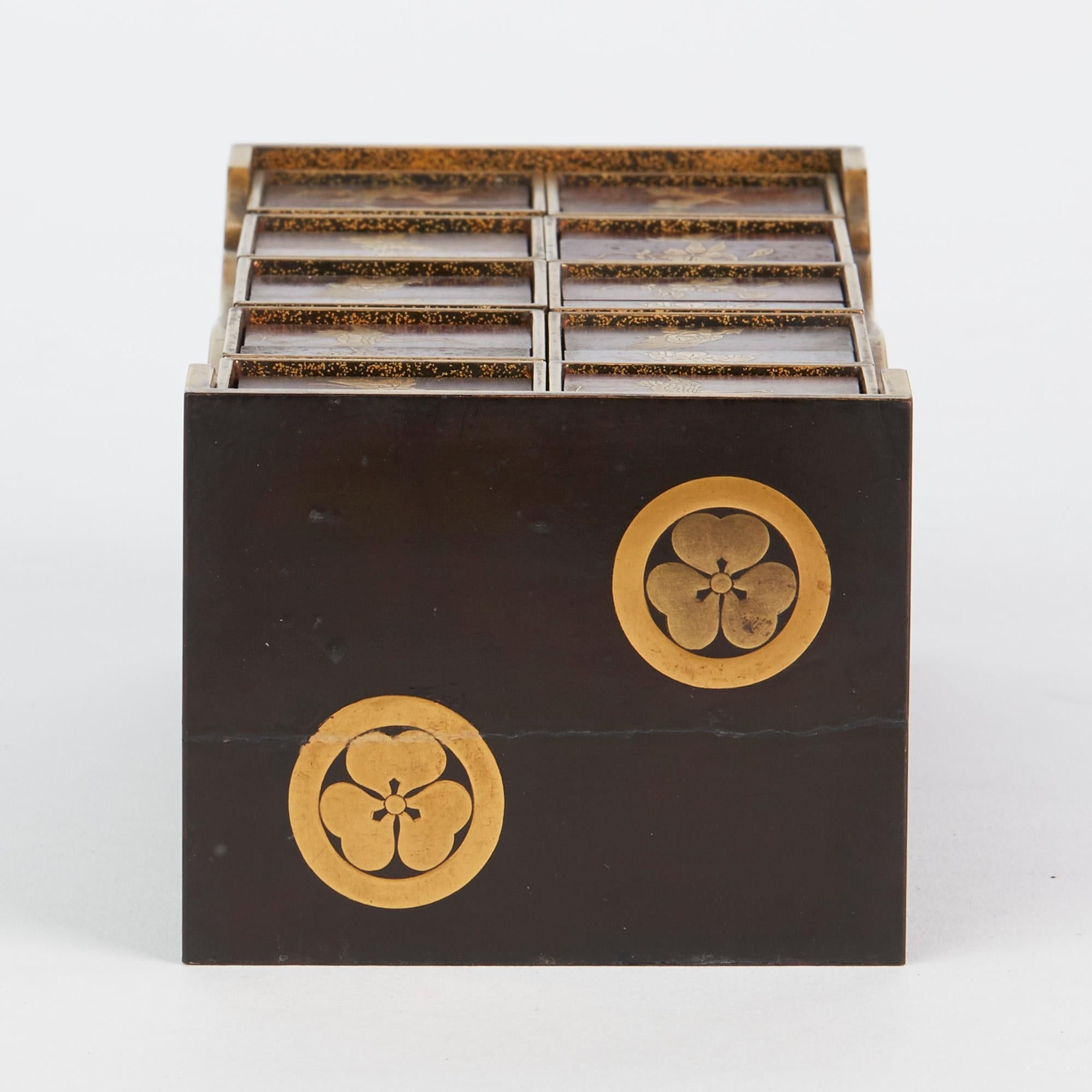An exceptional and rare antique Japanese lacquered wooden sensory game dating from the 19th century. This very finely made set comprises of a table shaped box decorated in gold with three leaf clover like designs with a gold lacquered shelf below