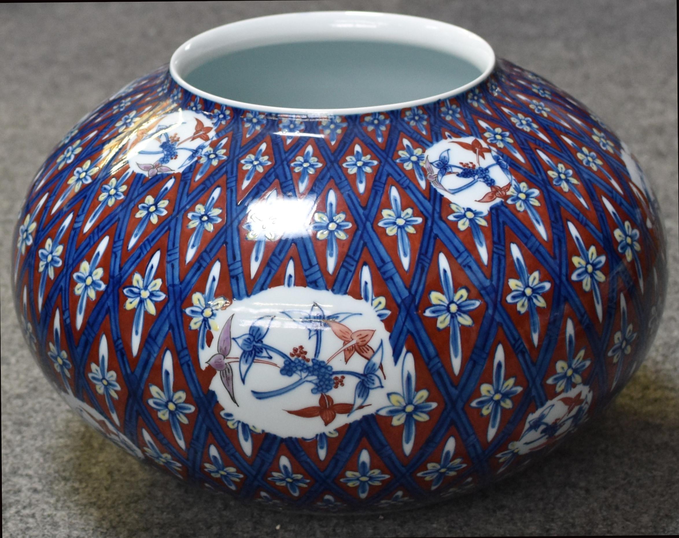 Extraordinary Japanese Contemporary museum quality decorative porcelain vase in a striking shape, intricately hand painted in blue, white and red to create a signature geometric pattern with blue lines showcasing bamboo branches. A masterpiece by a