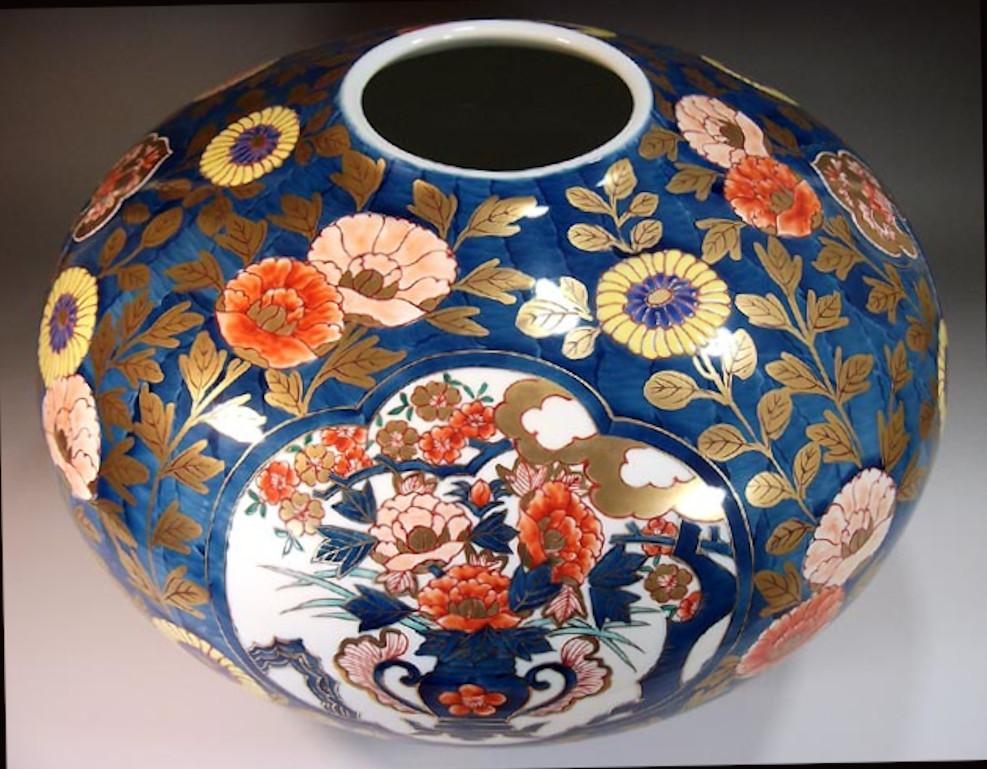 Exquis vase décoratif japonais contemporain en porcelaine, finement doré et peint à la main dans des teintes de rouge et de bleu sur un corps ovoïde saisissant, une œuvre signée par un maître porcelainier primé de la région d'Imari-Arita au Japon.