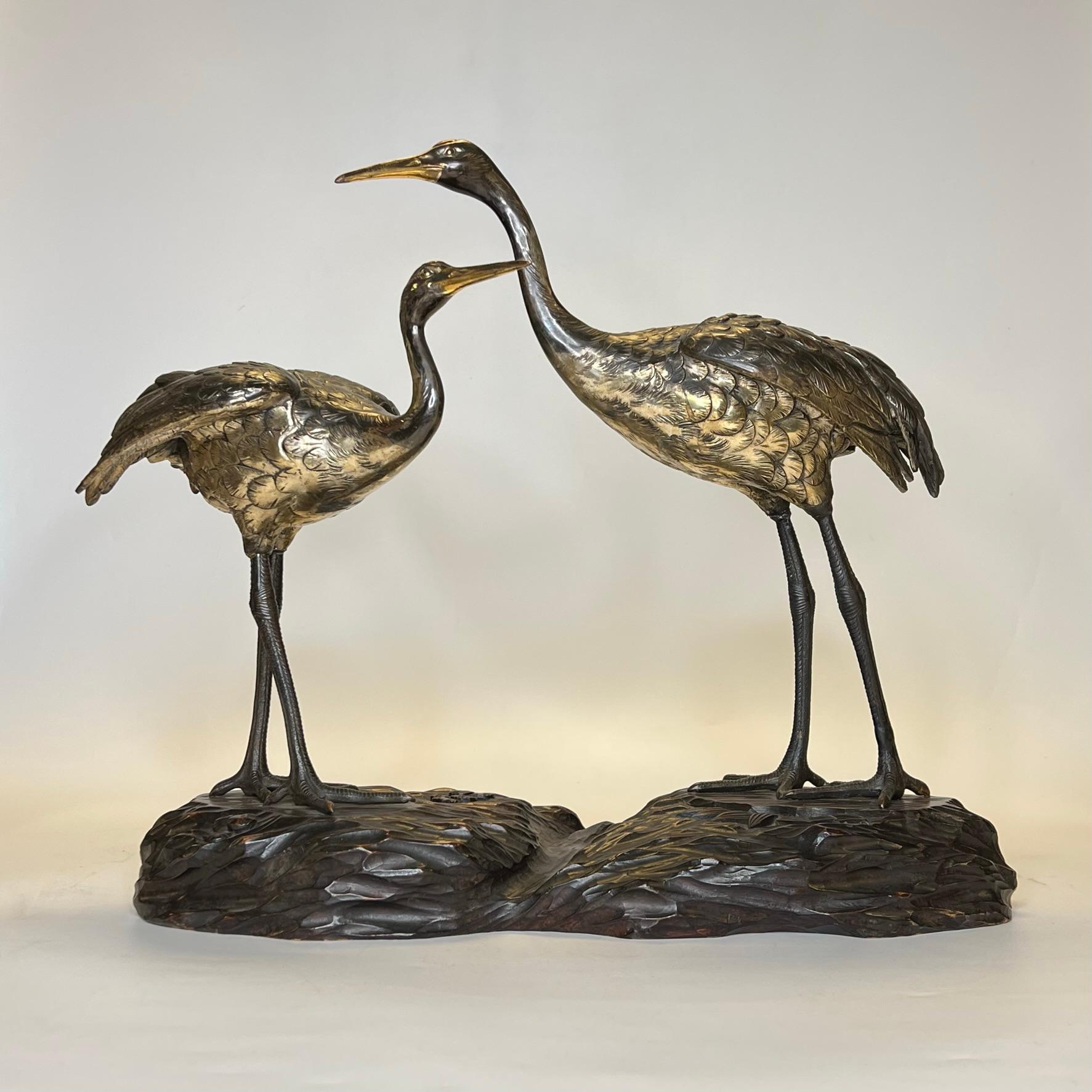 Our figure of two red-crowned cranes, also known as Manchurian and Japanese cranes, is finely sculpted, cast and cold-painted with gold wash. Apparently unsigned. 

Today one of the rarest cranes in the world, the species has been revered in