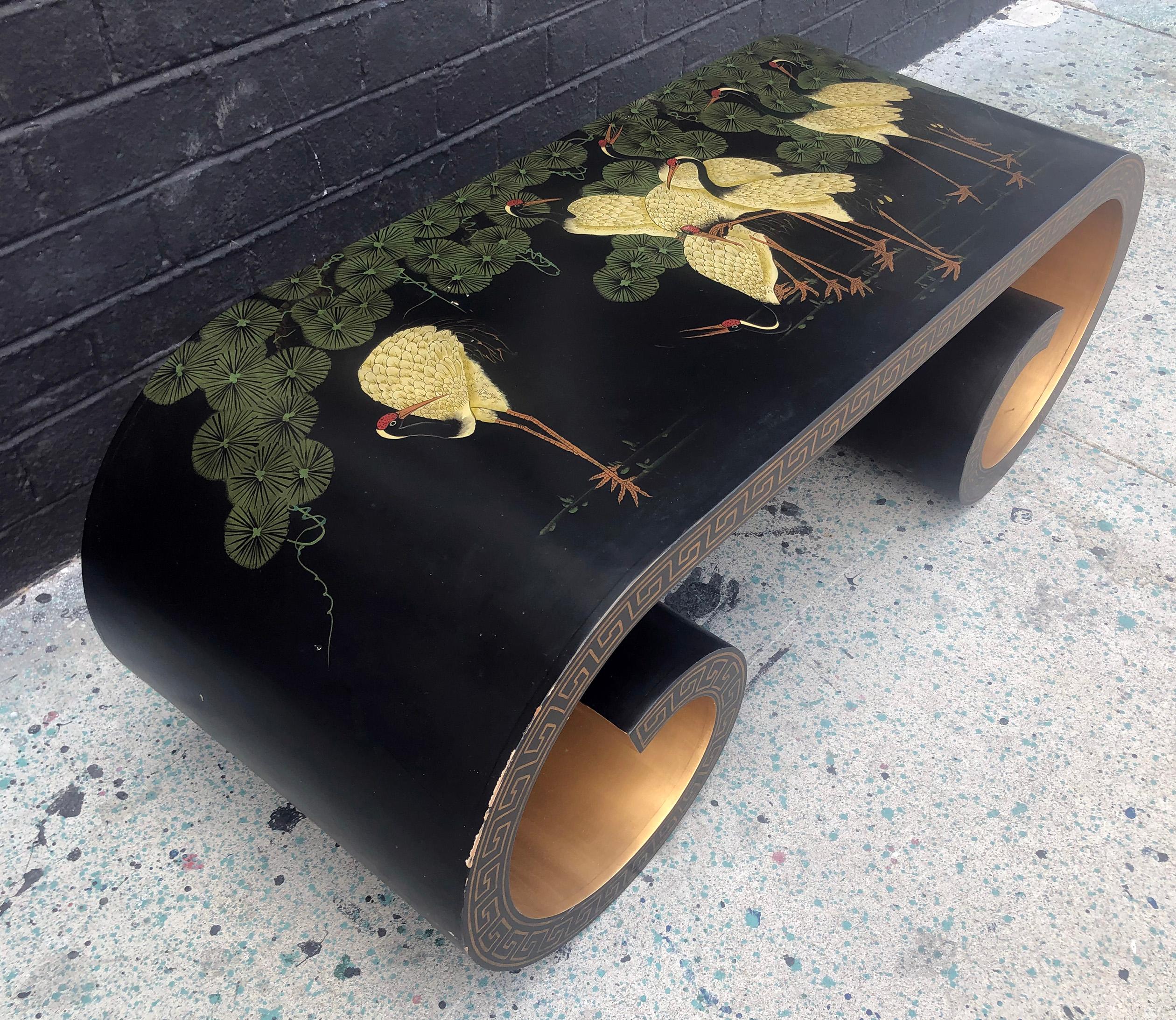 A stunning scroll shaped coffee table featuring red crowned cranes, gold gilt on the inside and featuring Greek key design along the outer edge

A great piece that is a perfect marriage of modern, Hollywood Regency and chinoiserie styles.