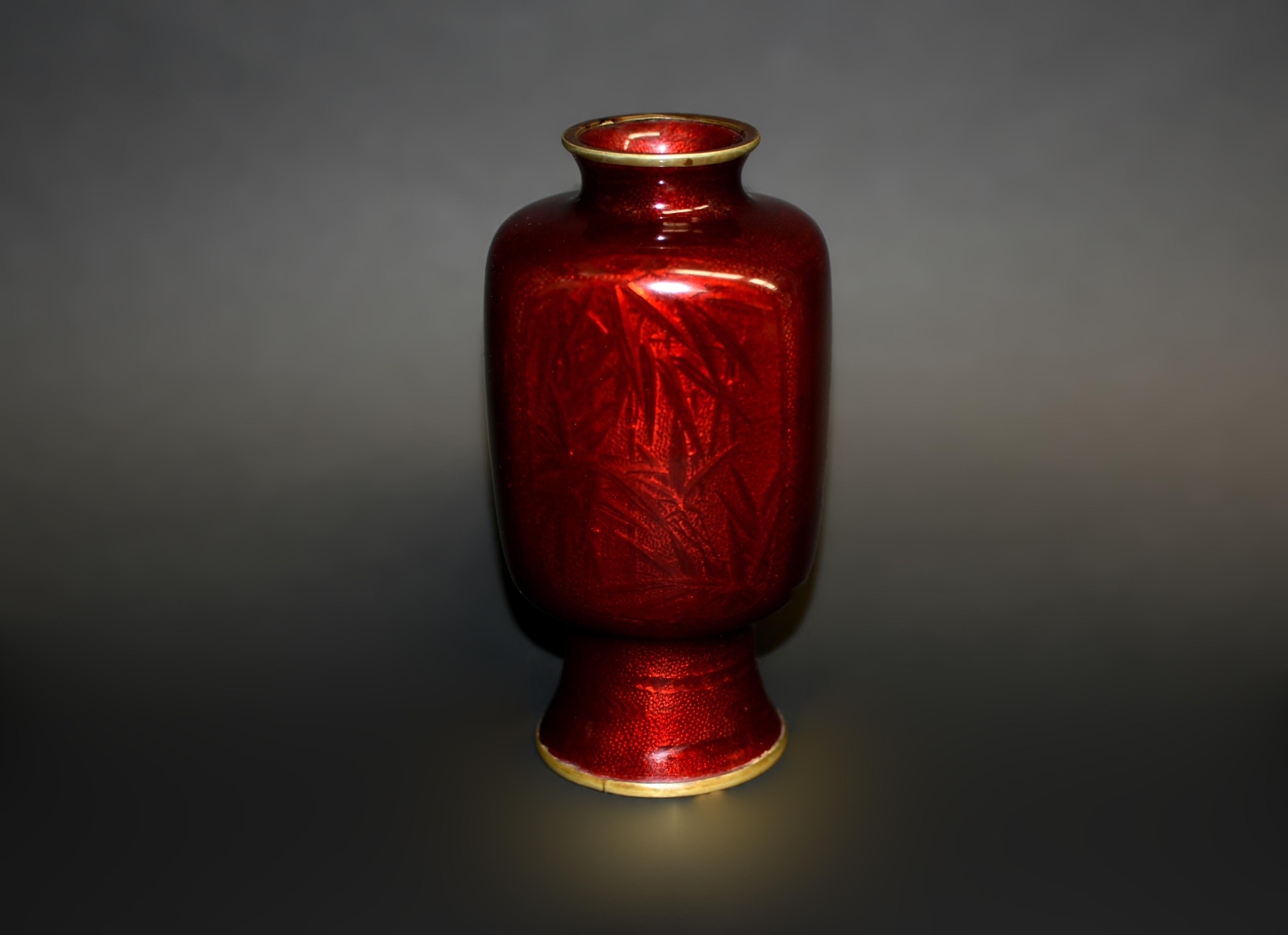 This exquisite vintage vase showcases the highly prized Ginbari cloisonné technique, where shimmering silver foils are applied beneath translucent enamel, creating a luminous, iridescent effect. Set against a striking metallic red background, the