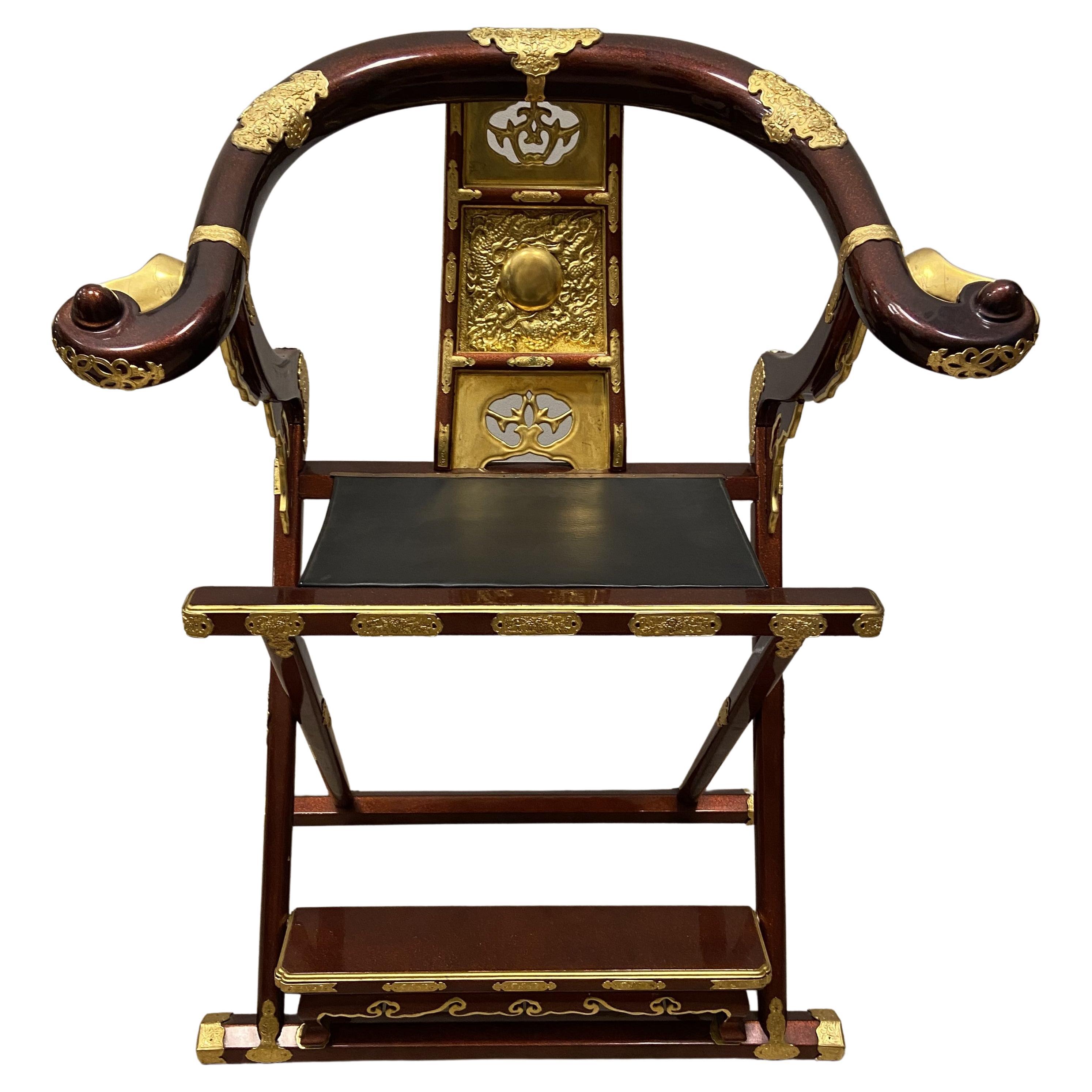 

 One of a kind kyokuroku, the name given to this type of folding meditation chairs for monks. Made of wood, it is lacquered in red with a glossy nashiji finish and decorated with golden hardware decorated with different types of plant elements,