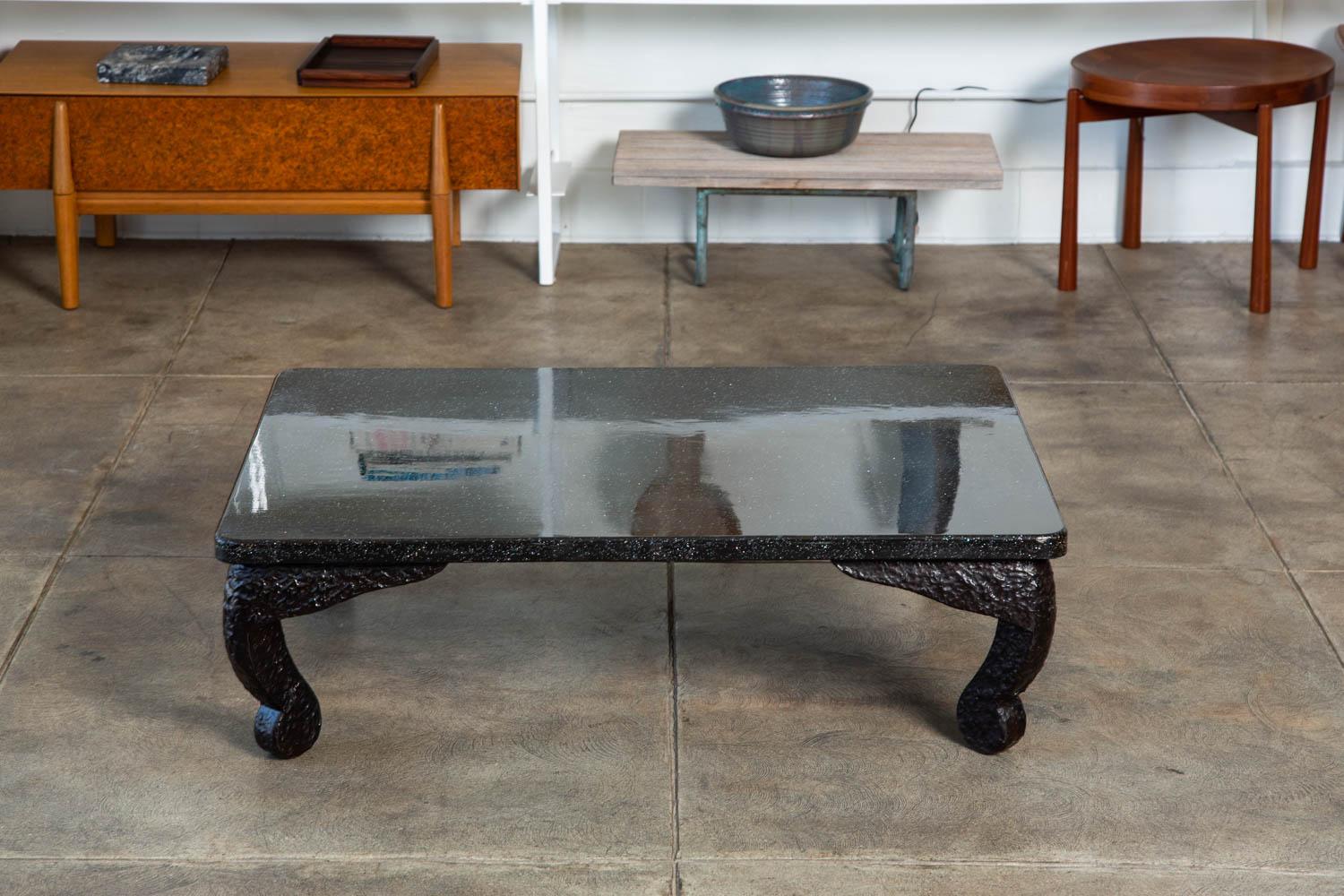 Japanese polished resin coffee table with carved textured resin legs. The black table features a smooth top with beautiful speckled detail, in contrast to the legs, that have a textured hammered look.

Condition: Excellent vintage condition,