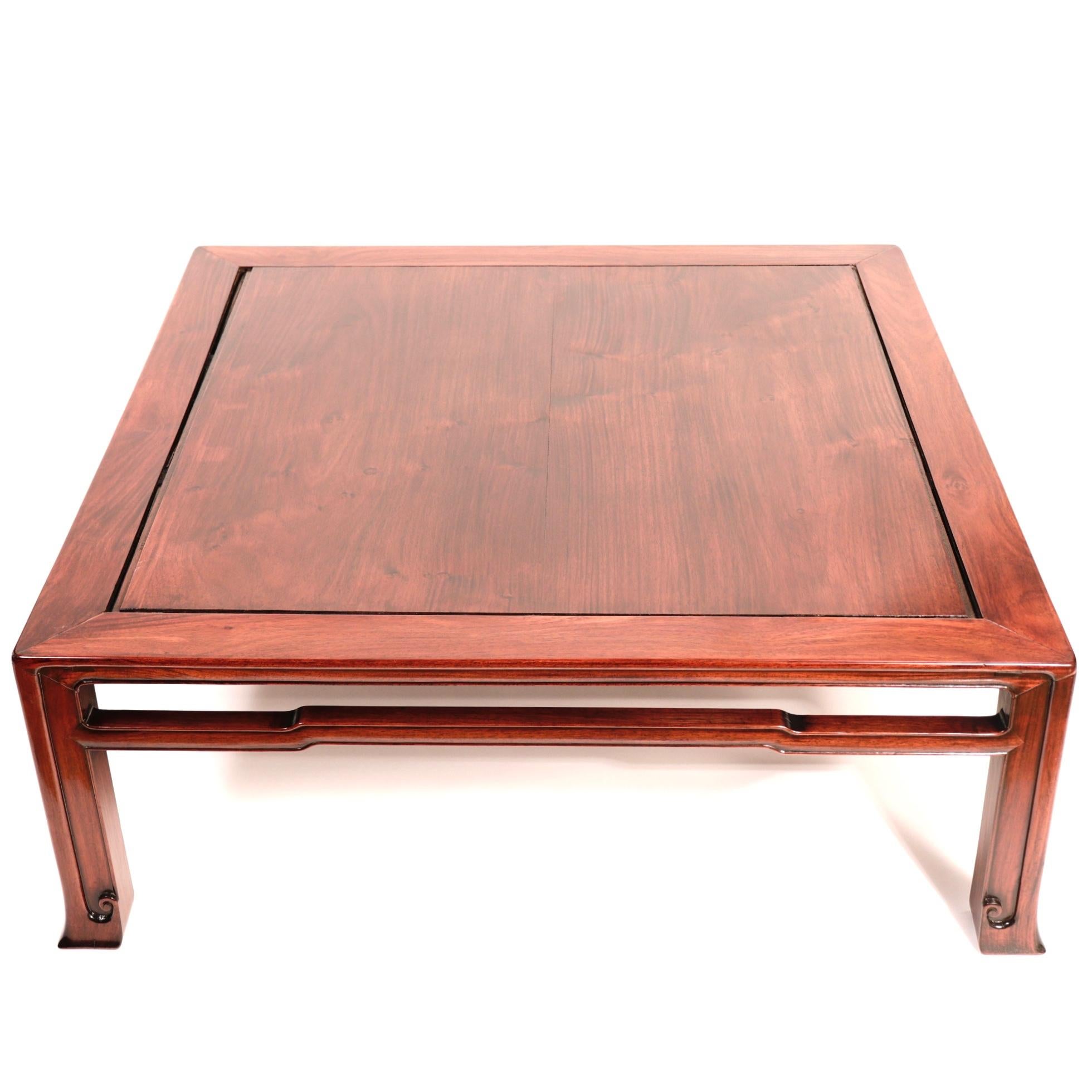 Japanese Rosewood Square Tea Table in Chinese style having tapered legs with bracket hoof feet, elbowed cross struts and center floating panel. Minor shrinkage, surface scratches, and signs of age otherwise fine condition.