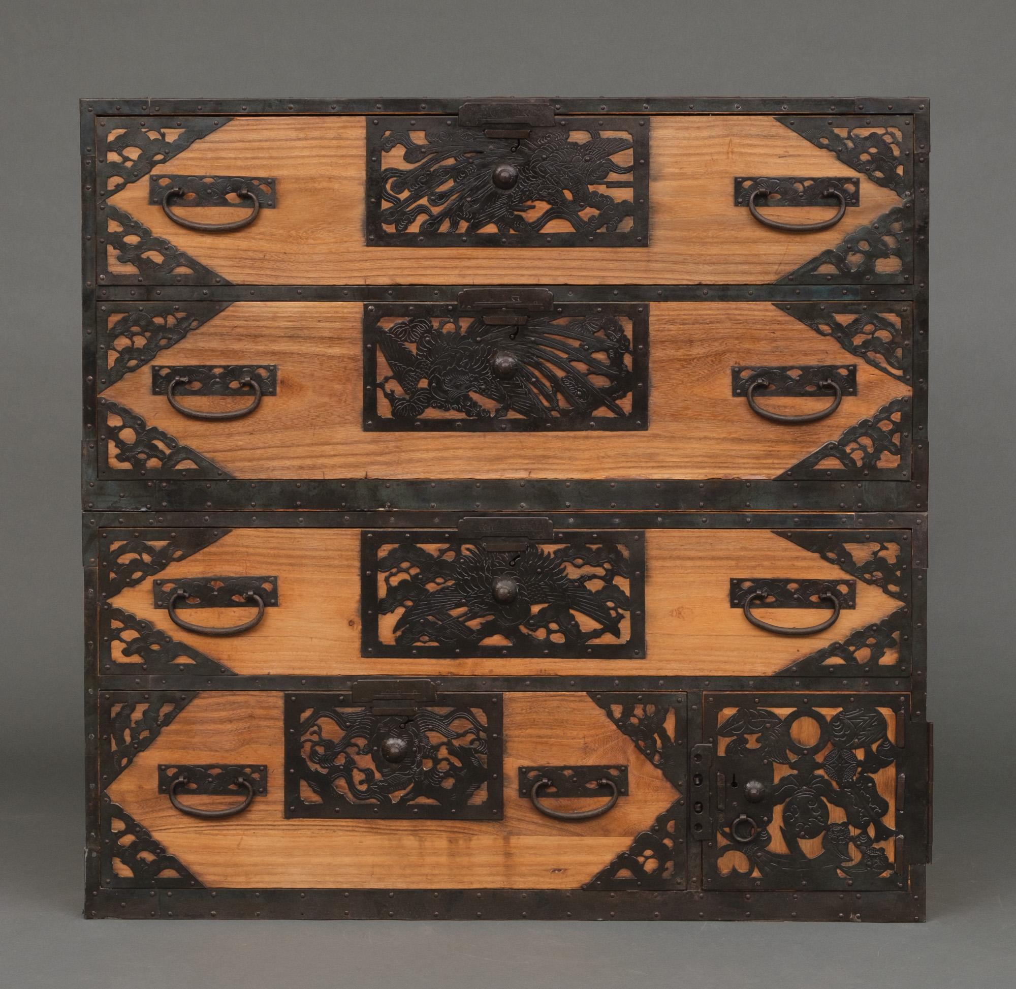 Exceptional, rare and completely restored wooden Sado ishô dansu (cabinet of drawers) with elaborately decorated open work iron hardware, in two sections. Fully restored, cleaned and waxed.

The exterior is made of hinoki cypress wood. Only slightly