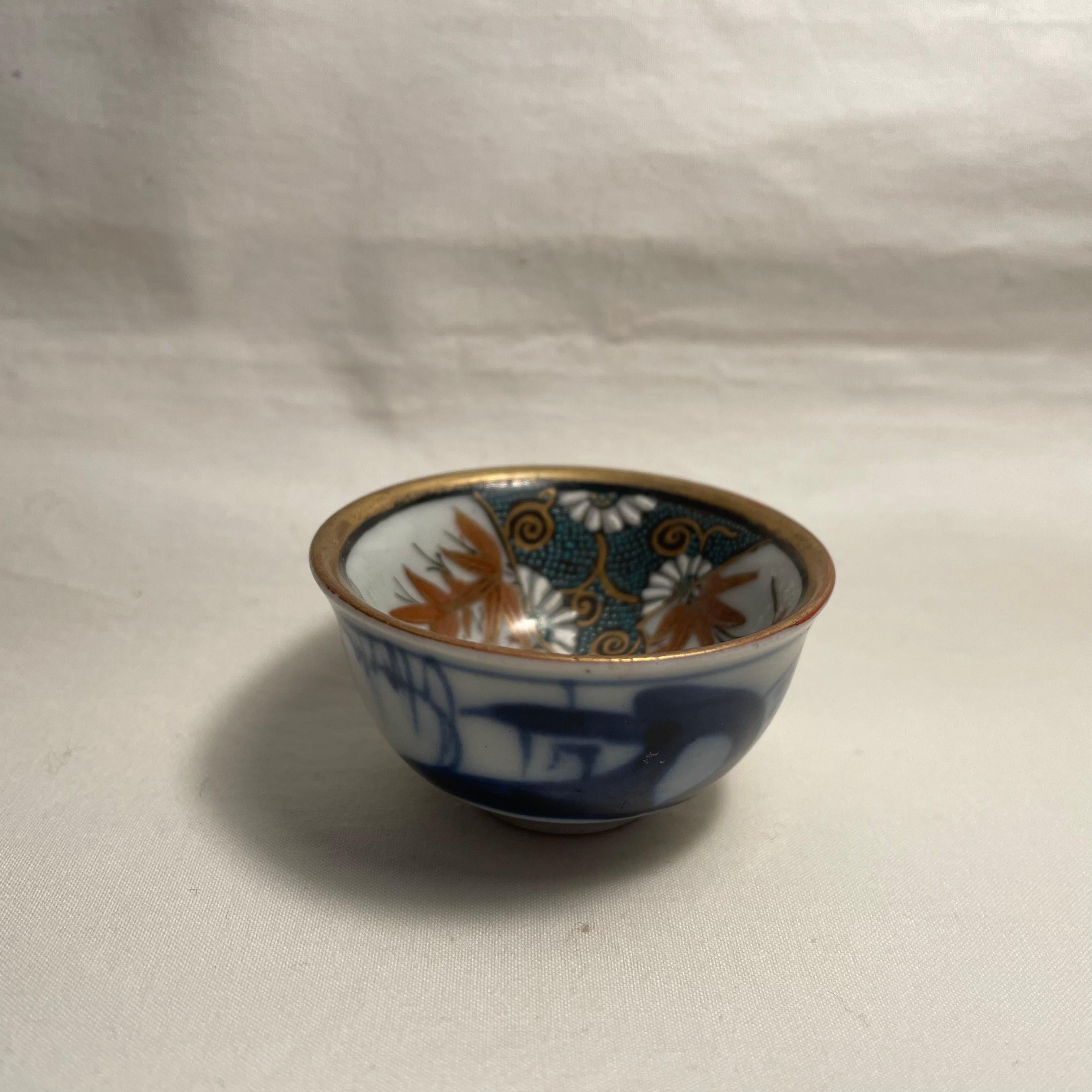 This is a small cup for drinking sake. It is called Ochoko in Japanese.
It was made in showa era around 1960s.  It is made with porcelain and all hand painted. 
This is Kutani ware.
Design is with a plum, a pine and bamboo.

Dimensions:
5,3 x 5,3 x