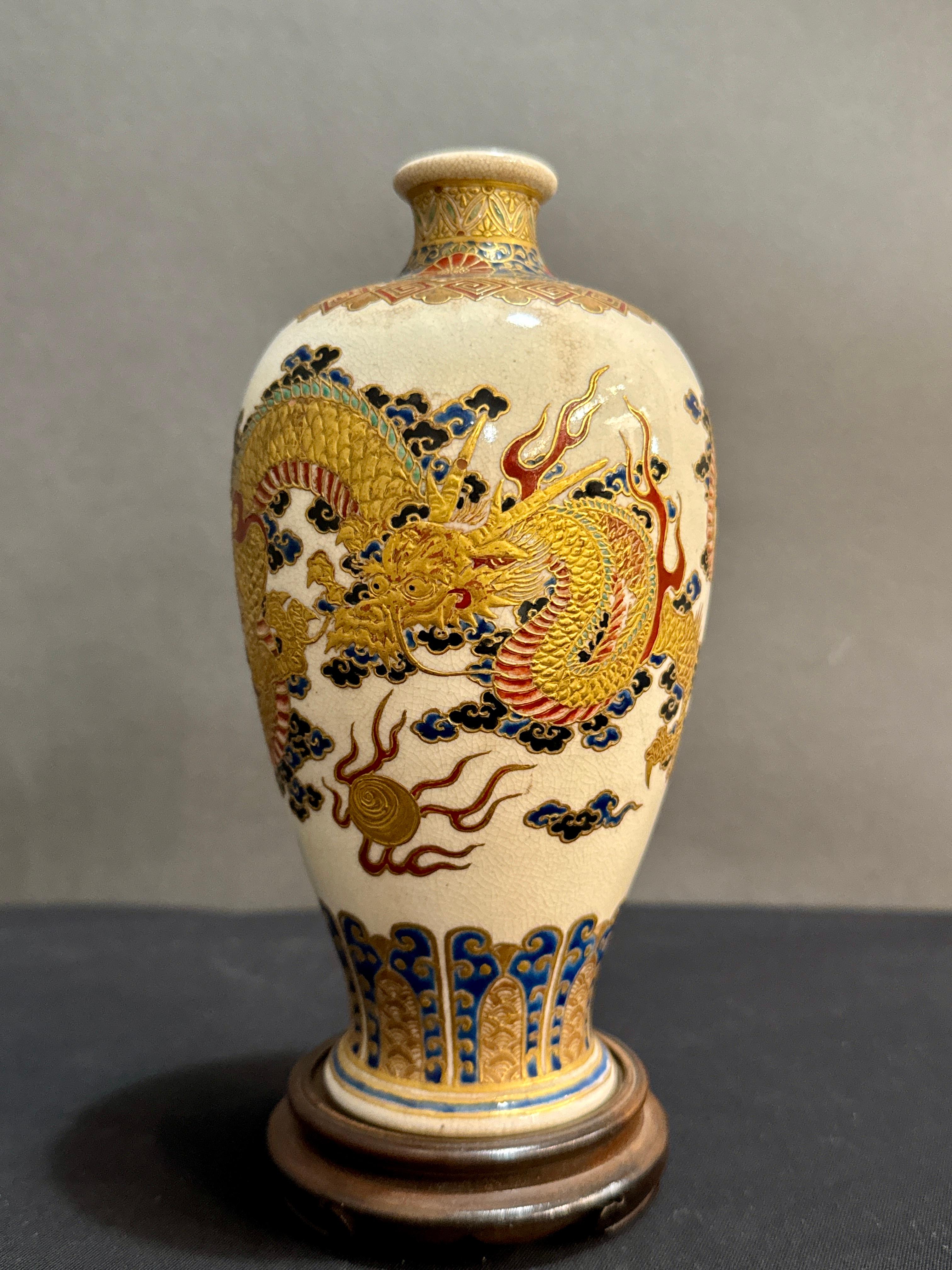 Un fantastico piccolo vaso giapponese Satsuma con immagine di draghi che si contorcono, periodo Meiji, circa 1900, Giappone.

Il vaso ha un'elegante forma a balaustro, con piede leggermente svasato, corpo sottile, spalle alte, collo corto e bocca