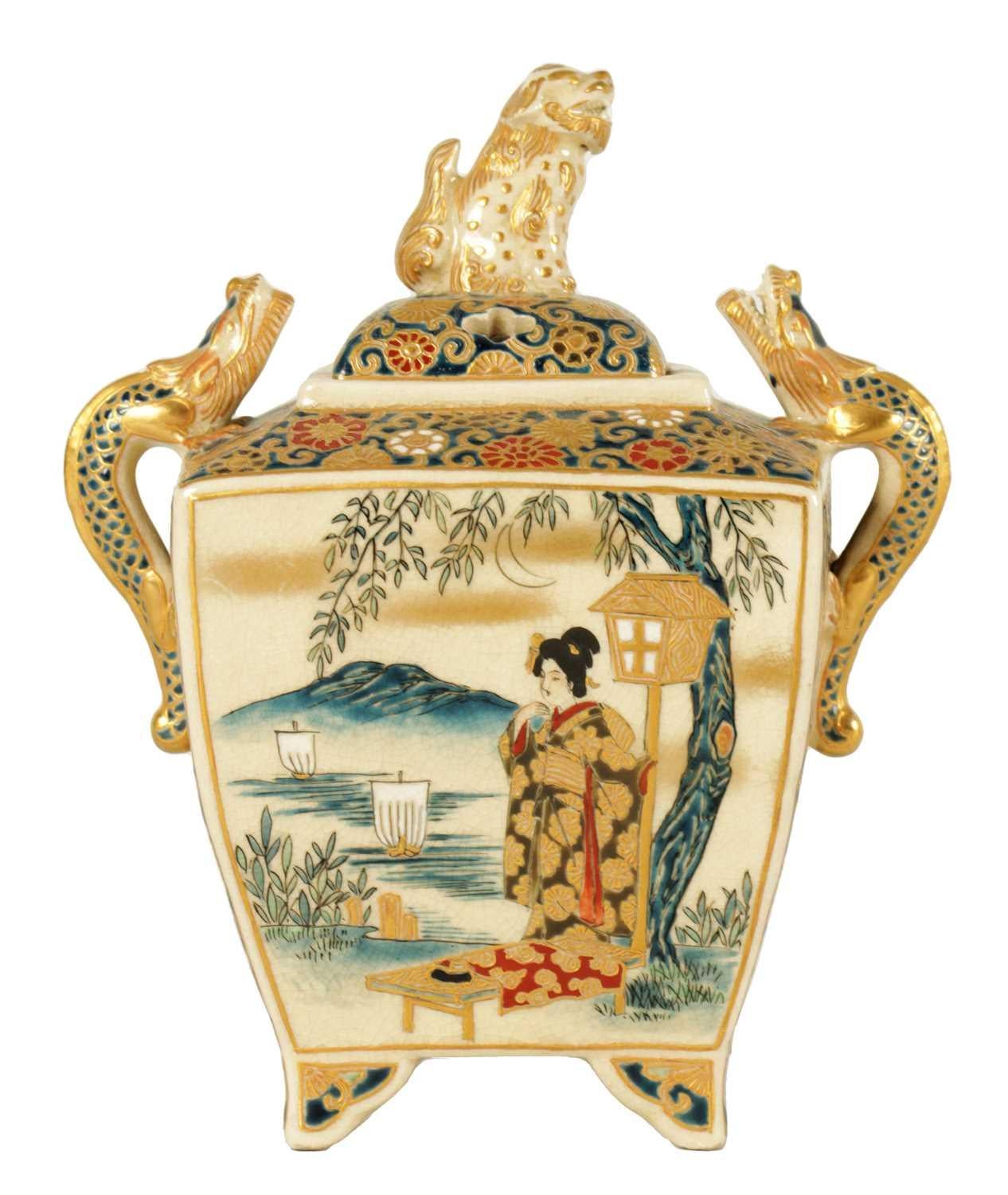 A small exquisite Japanese Meiji Period satsuma Koro of square tapering form, fitted with dragon handles and a foo dog finial, finely gilded and decorated with female figures in landscape settings with tree, mountain, lake with boats and
