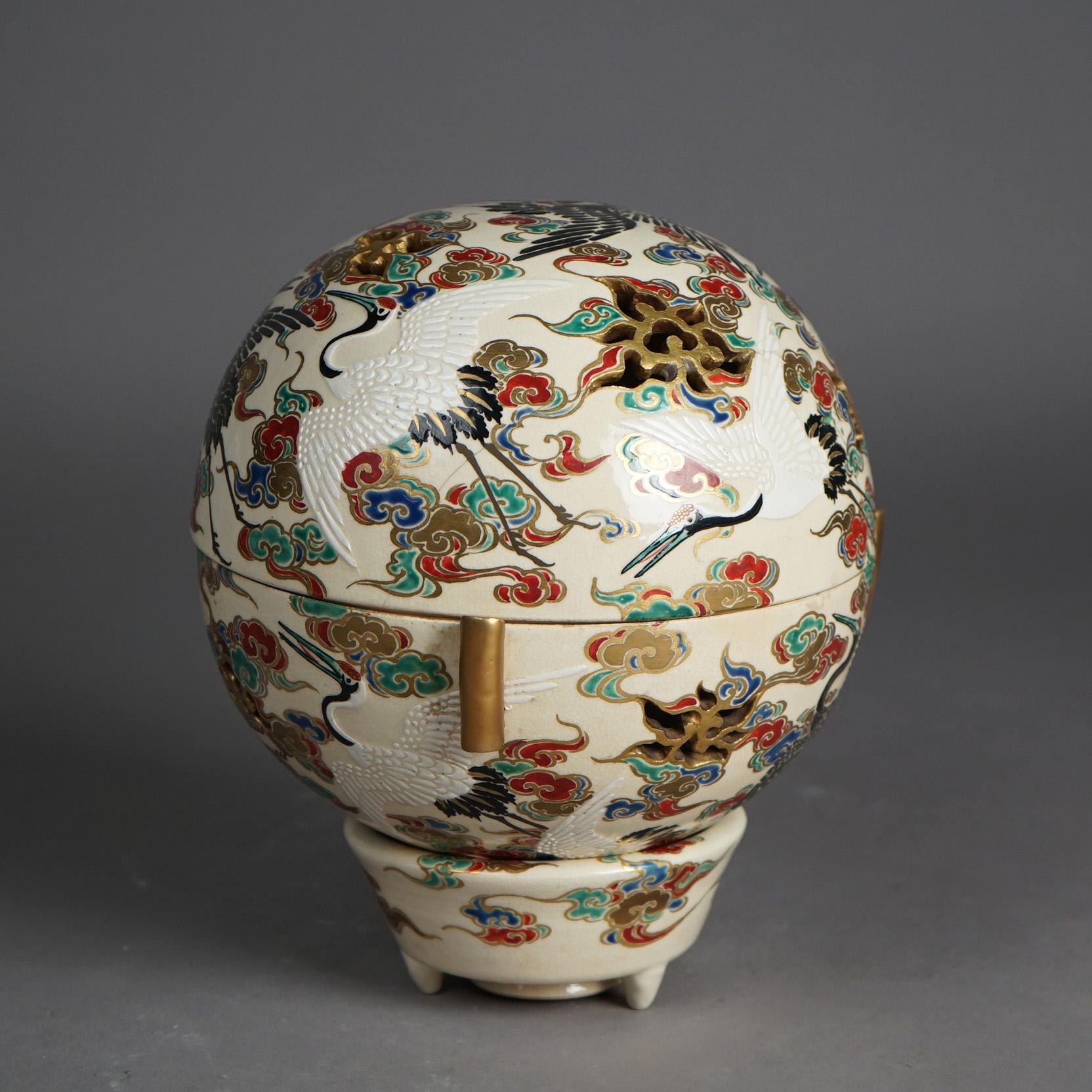 An antique Japanese Satsuma Meiji footed censer offers porcelain construction in globe form with hand painted and gilt all-over garden scene having heron and floral elements, c1910

Measures - 9 1/2