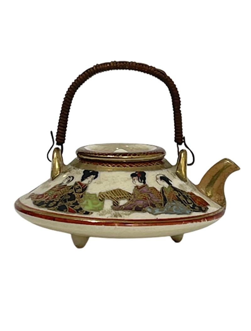 Japanese Satsuma miniature tripod teapot and cover, Meiji period

A circular flattened form miniature teapot with cover painted in enamels and gilt
The teapot has a panoramic scene of a man, woman and 2 children sitting, dressed in kimonos.
The